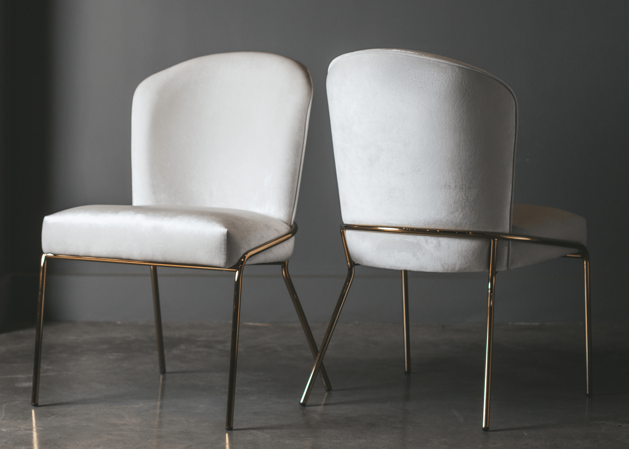 Ambiente moderno com a Cadeira Évora, estrutura dourada e estofado refinado.