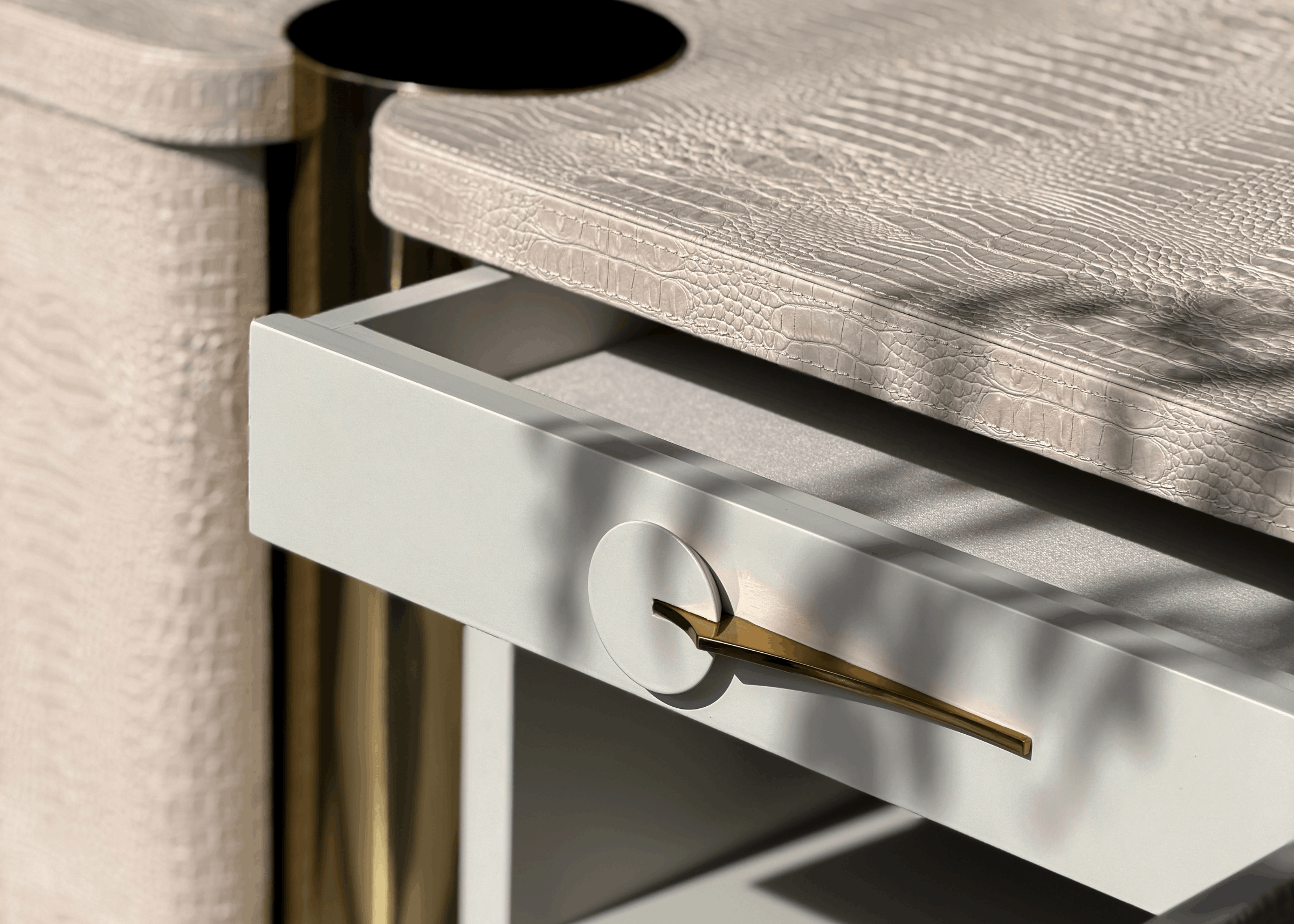 Cômoda Heron com estrutura em MDF revestida em laca croco e pés em aço inox dourado, móvel elegante para quartos ou salas sofisticadas.