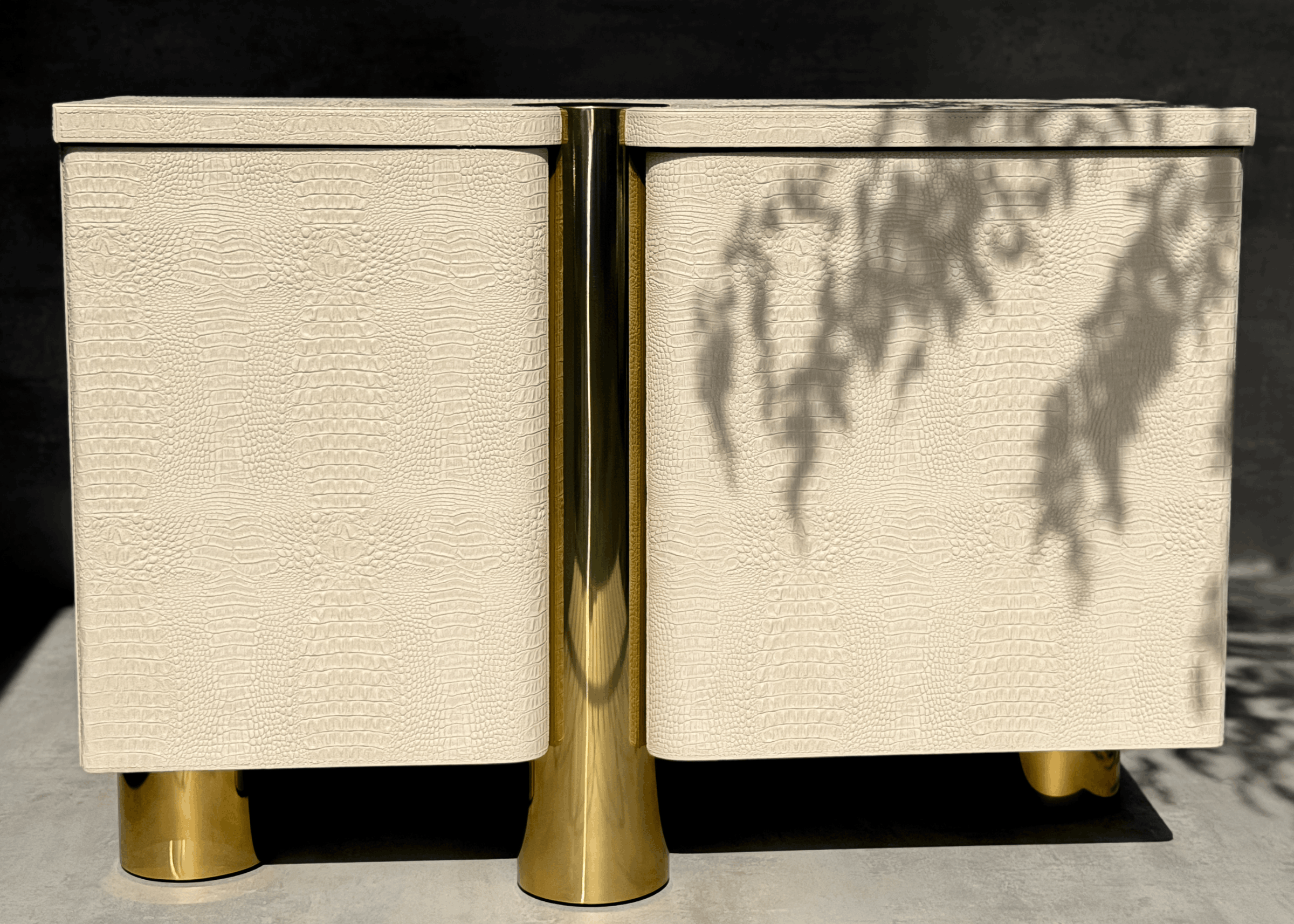 Vista frontal da Cômoda Heron com portas curvas, acabamento croco e base metálica dourada, peça sofisticada para ambientes contemporâneos.