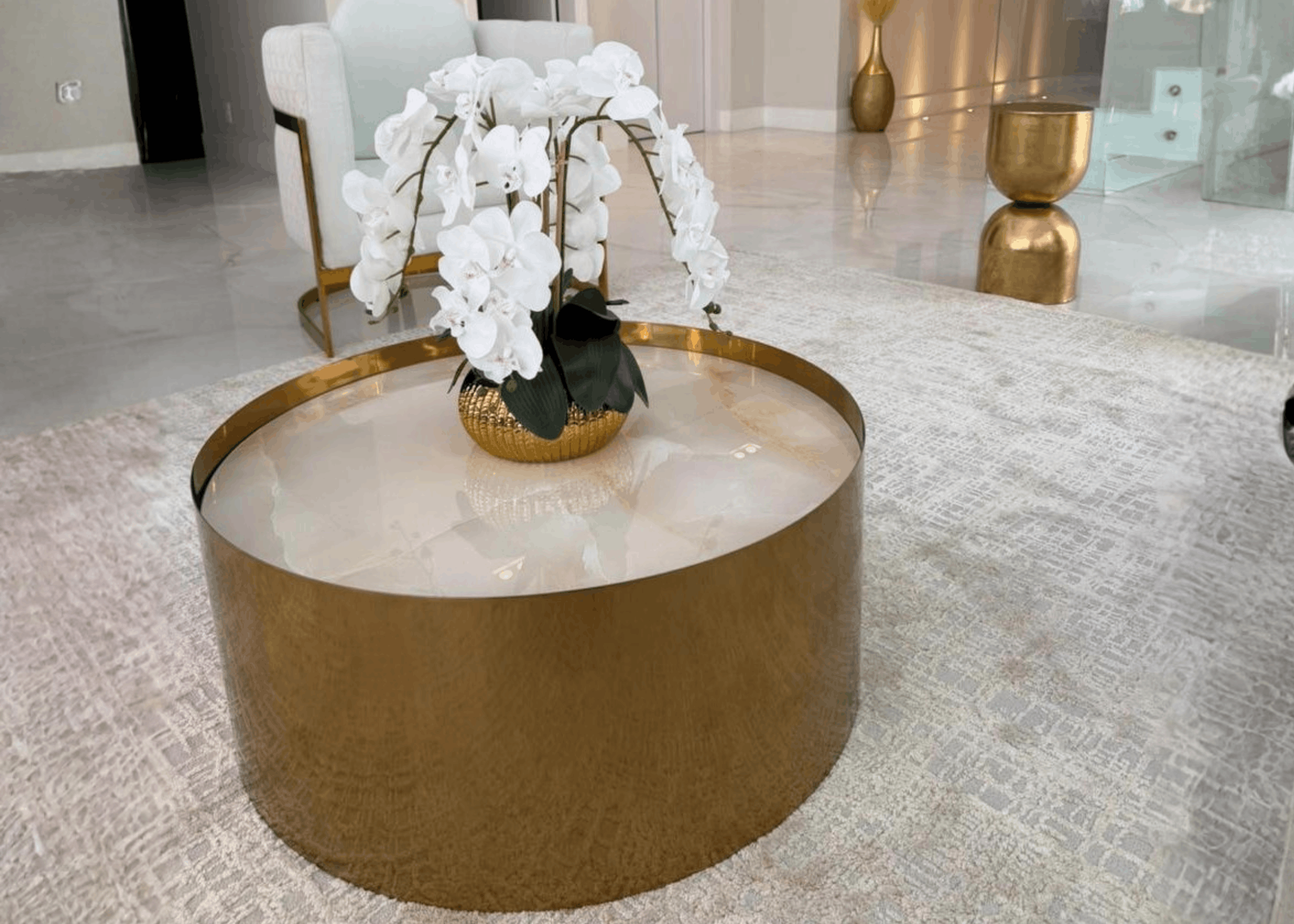 Detalhe da mesa de centro Lys com arco metálico em aço inox, destacando design exclusivo e acabamento refinado.
