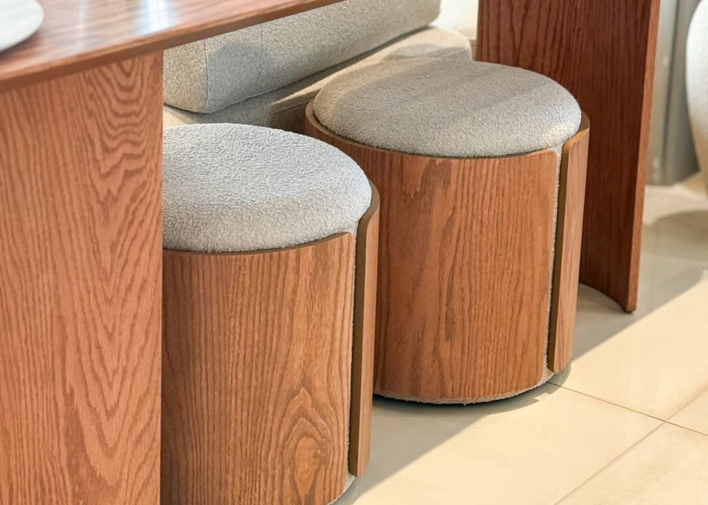 Puff Cylen com base em madeira natural e estofado premium, móvel compacto para ambientes elegantes e funcionais.