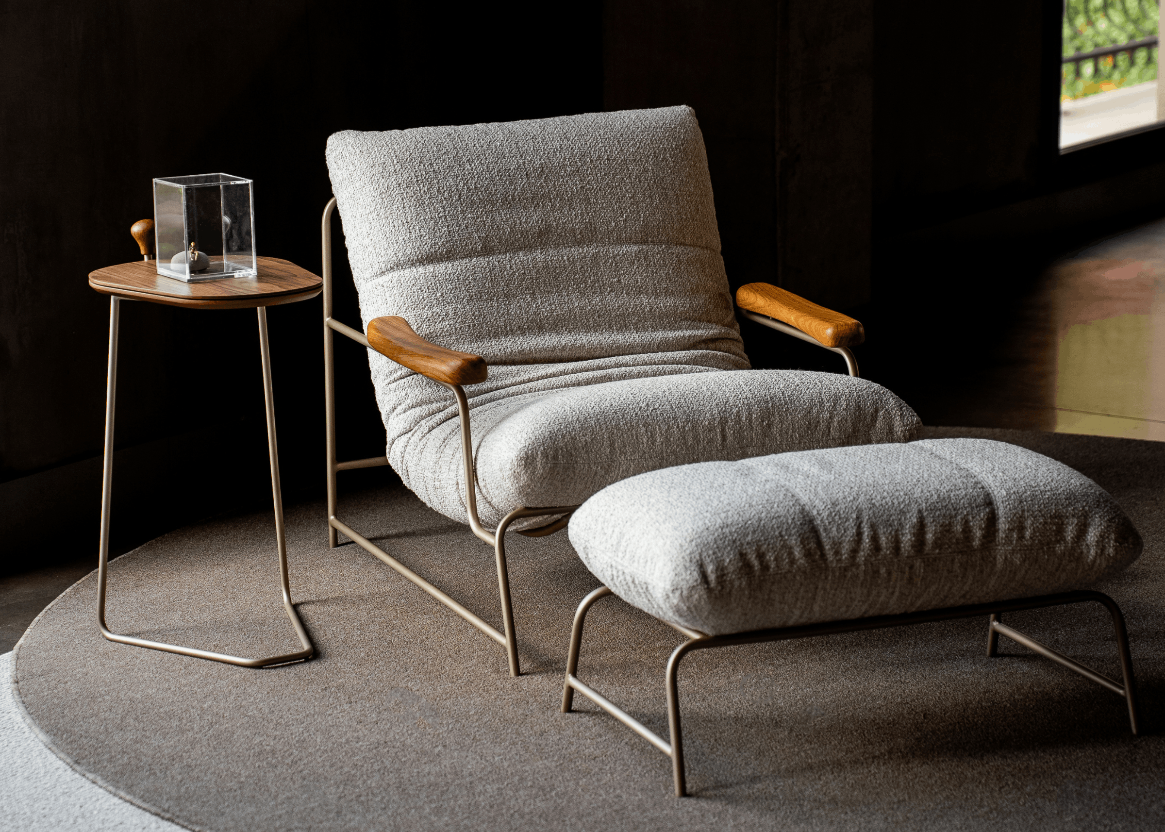 Poltrona Estelle com estrutura metálica e detalhe traseiro em lâmina, peça sofisticada para sala de estar contemporânea.