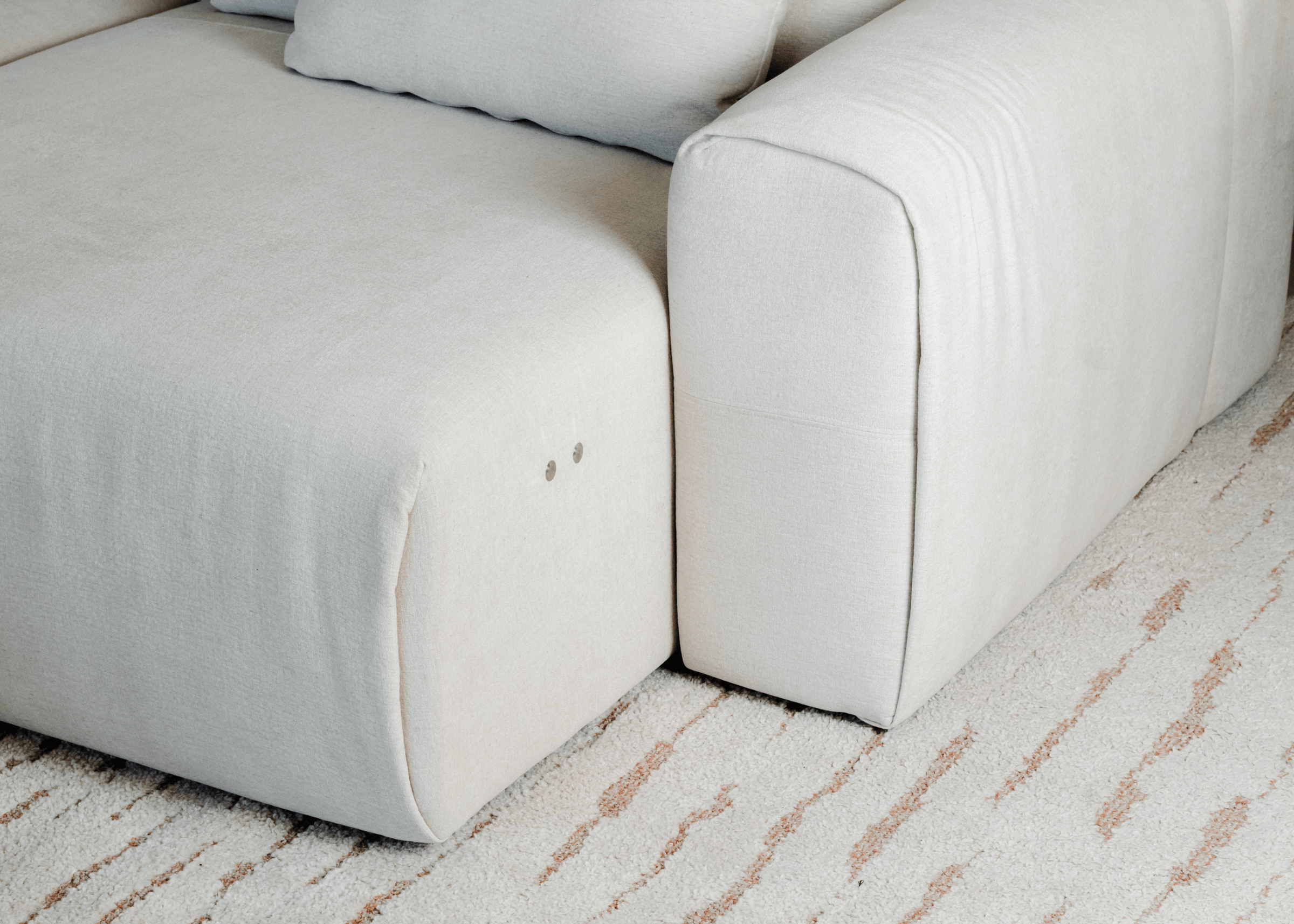 Close do comando discreto do Sofá Dante, tecnologia integrada em peça estofada moderna para salas atuais.