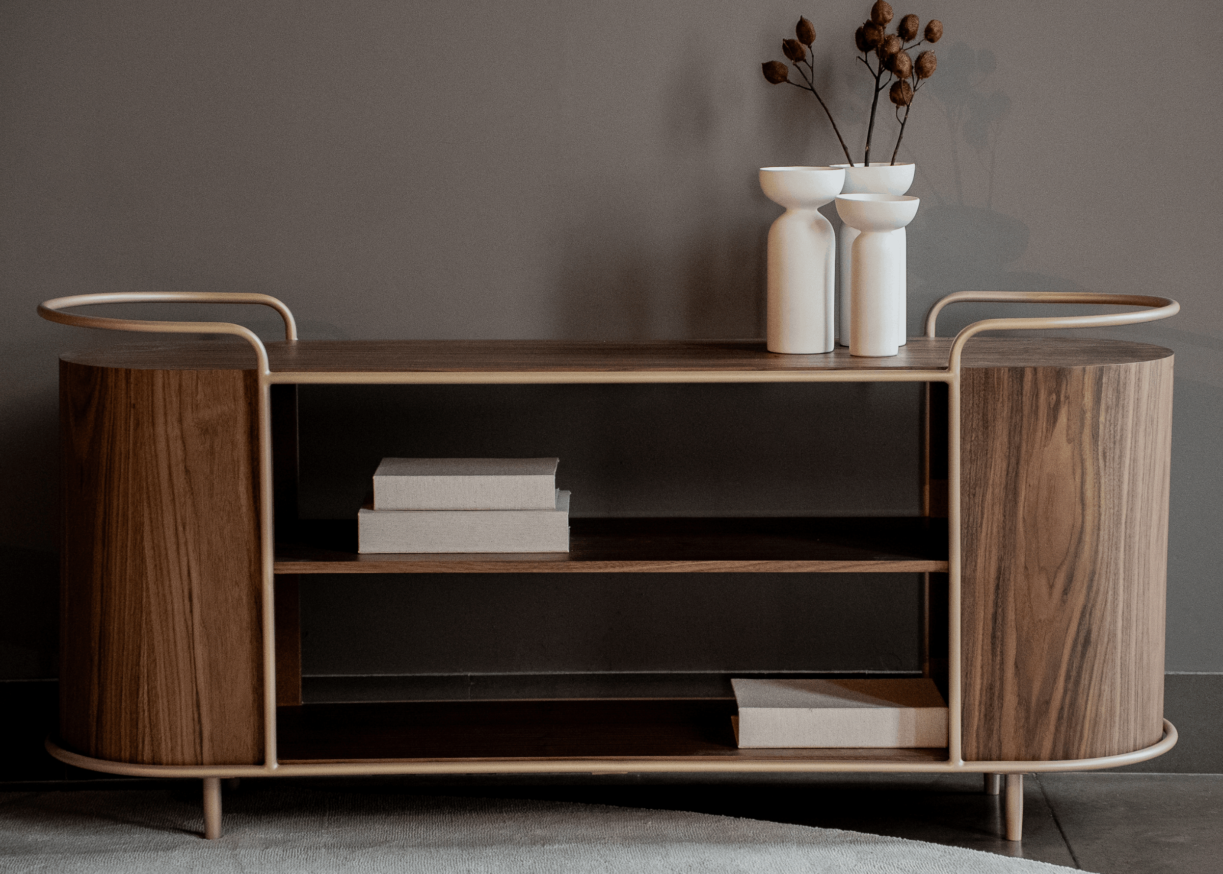 Aparador Breno com prateleiras internas amplas para livros e decoração, estrutura metálica clara e acabamento amadeirado moderno.