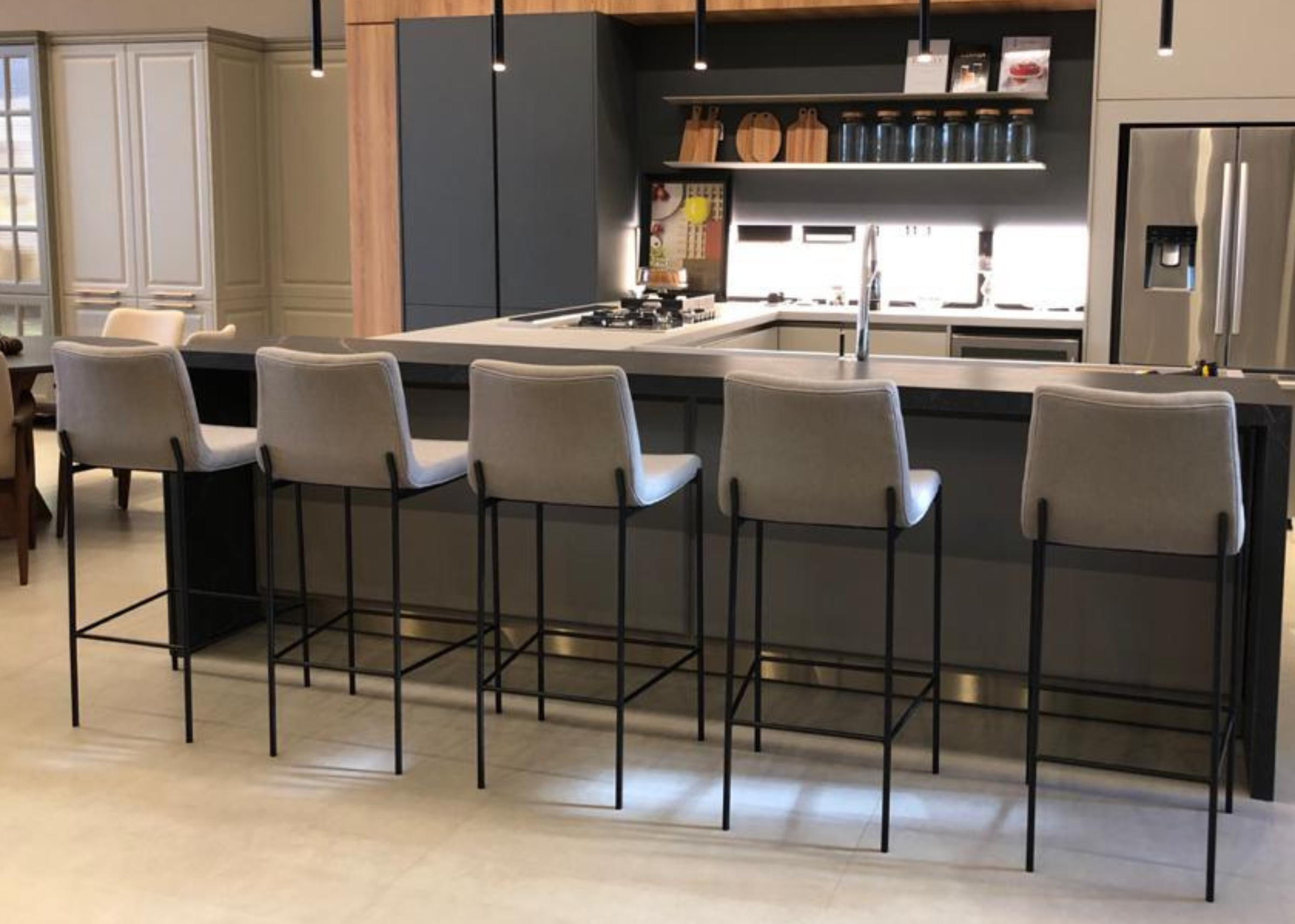 Banqueta Girassol ideal para bancadas elegantes, com base preta e revestimento em tecido cinza que combina sofisticação e conforto, trazendo um toque contemporâneo ao ambiente.