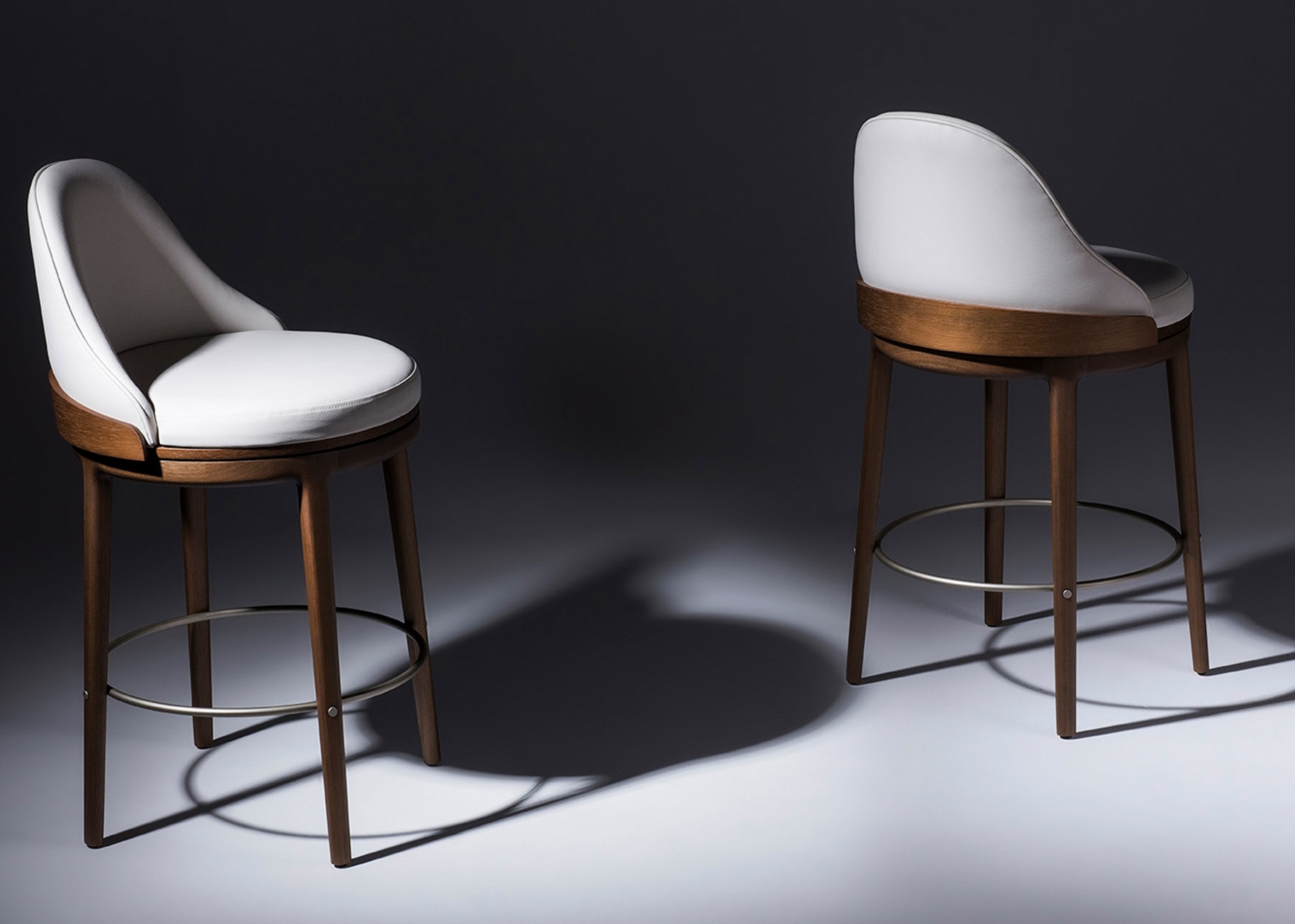 Banqueta giratória Aveline I com base em madeira, apresentando design elegante e confortável, ideal para compor ambientes modernos e sofisticados.