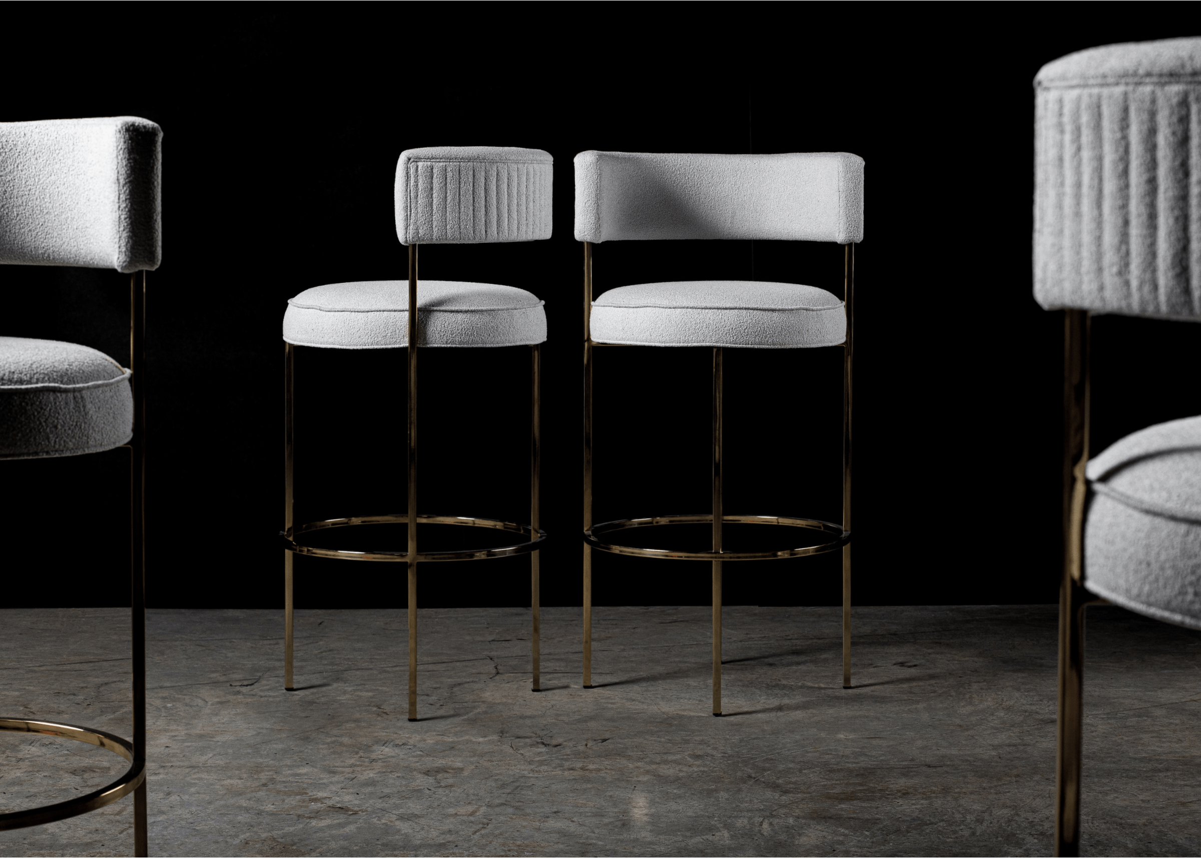 Banqueta modelo Liane com assento em bouclé cinza e base metálica. Design contemporâneo e elegante, ideal para composições sofisticadas, apresentada sobre fundo neutro.