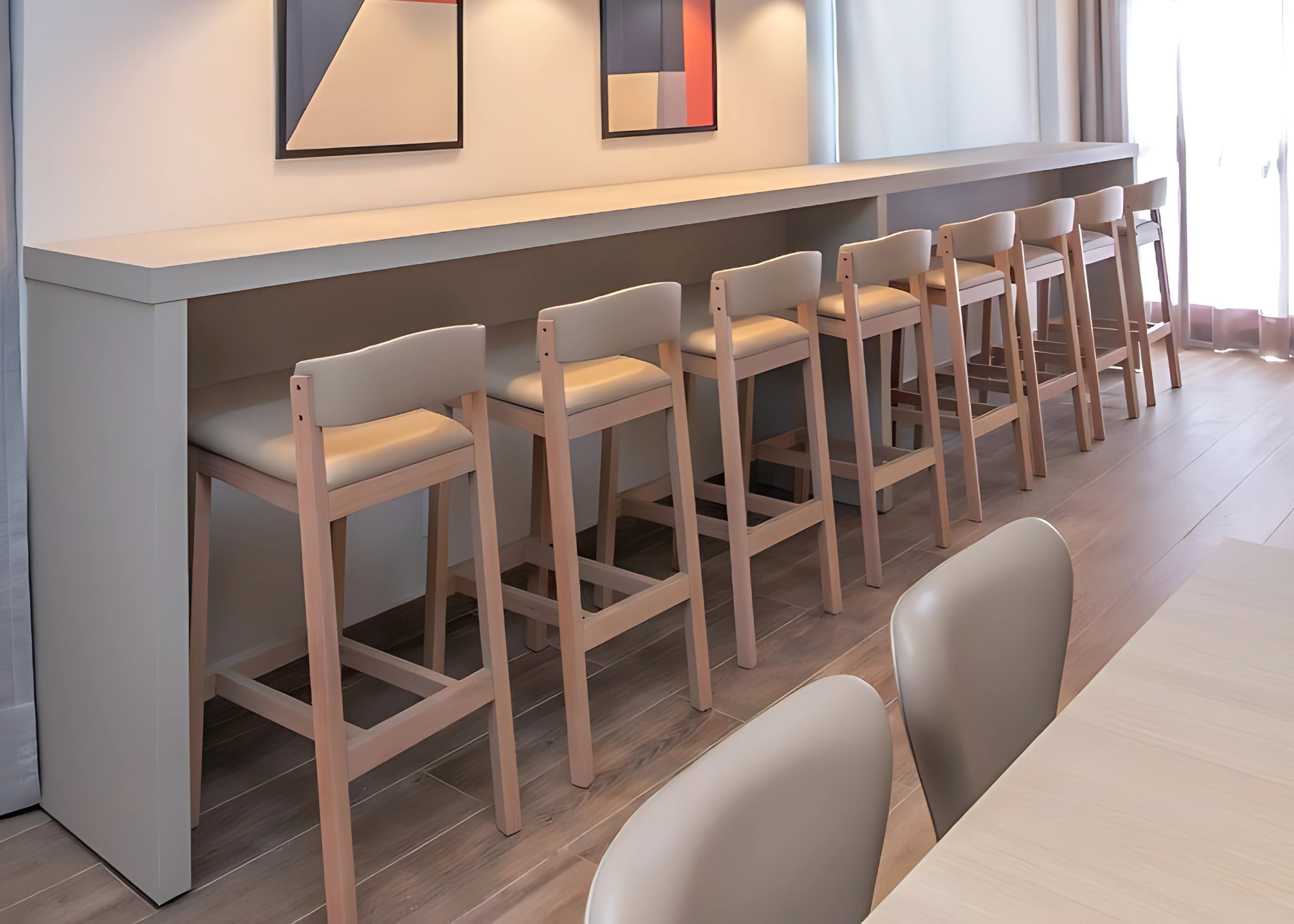 Banqueta Acácia para a sua bancada, estofada em tecido bege de alta qualidade, unindo conforto, durabilidade e elegância para valorizar o ambiente.