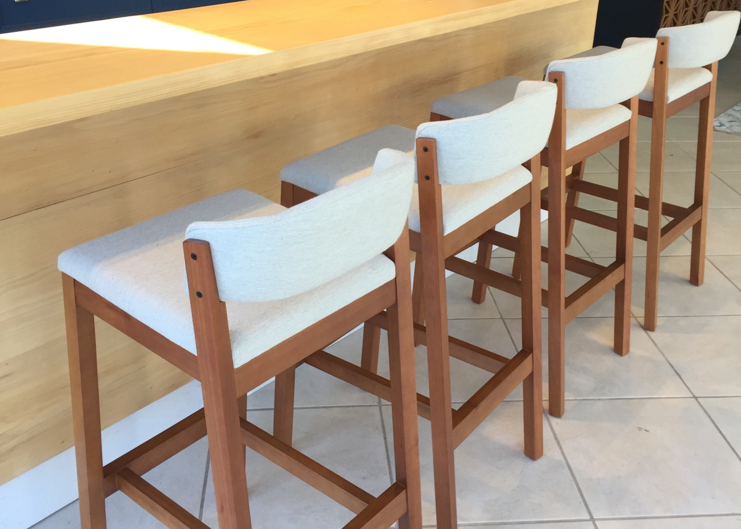 Banqueta Acácia para a sua bancada, com acabamento em madeira, perfeita para compor um ambiente elegante e sofisticado com conforto e estilo.