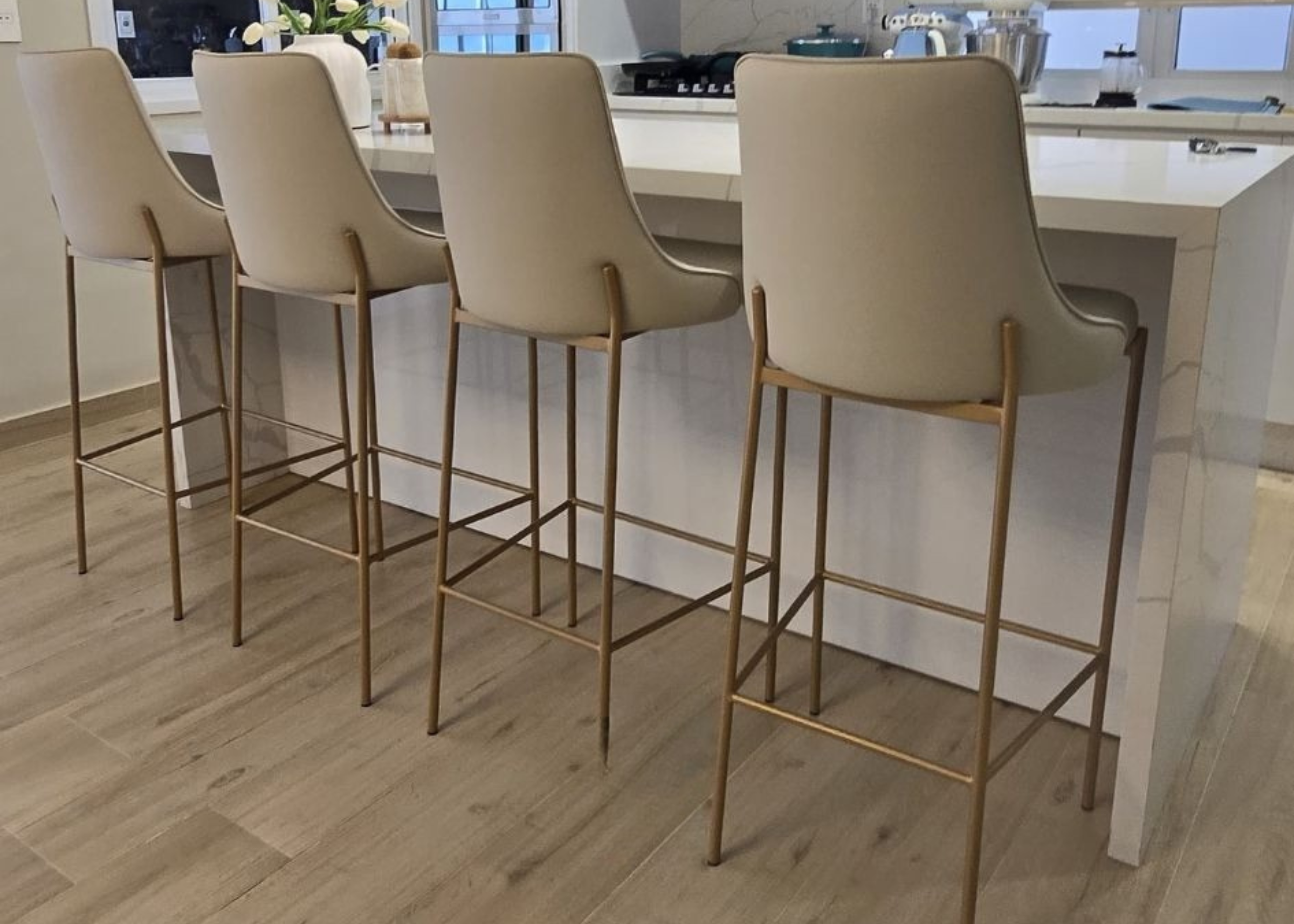 Banqueta Astrid para sala de jantar, com design moderno, base dourada e assento para bancada, ambientada. Móvel sofisticado e funcional para espaços contemporâneos.