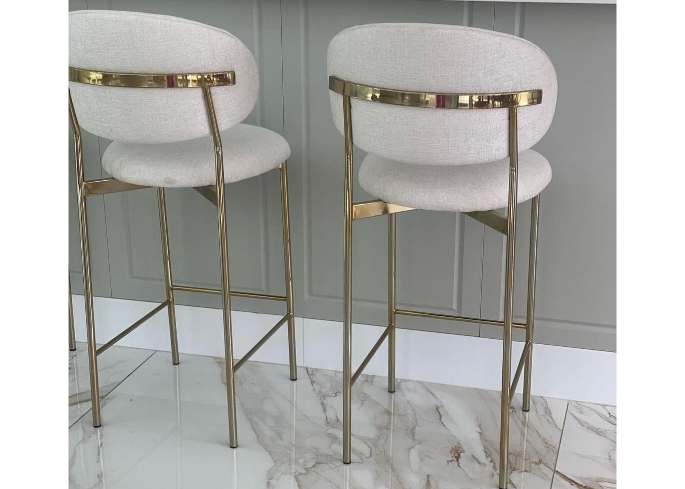 Banqueta Master sofisticada e elegante, com base em aço golden e estofado, disposta num ambiente moderno. Móvel de design refinado para bancadas e áreas gourmet contemporâneas.