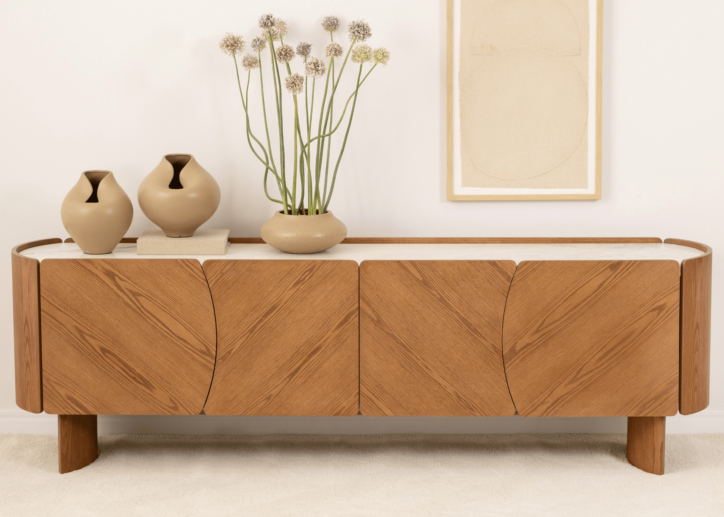 Buffet Alpi em mármore decorado com vasos e flores secas, trazendo sofisticação à sala de estar.