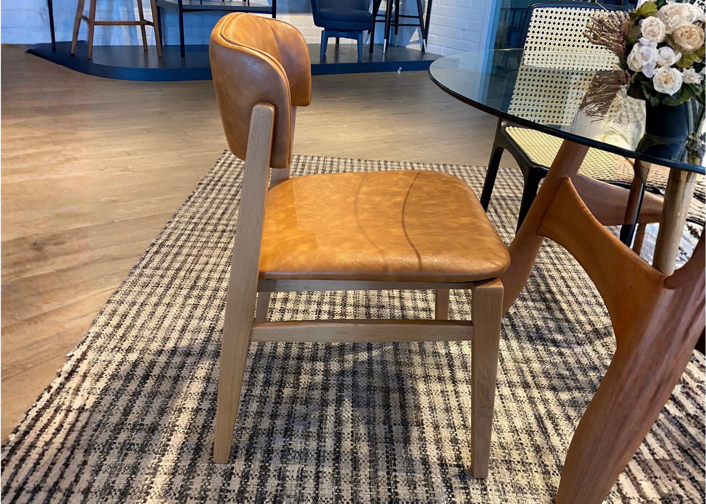 Cadeira laminada e estofada com design sofisticado, ideal para compor ambientes elegantes e acolhedores.