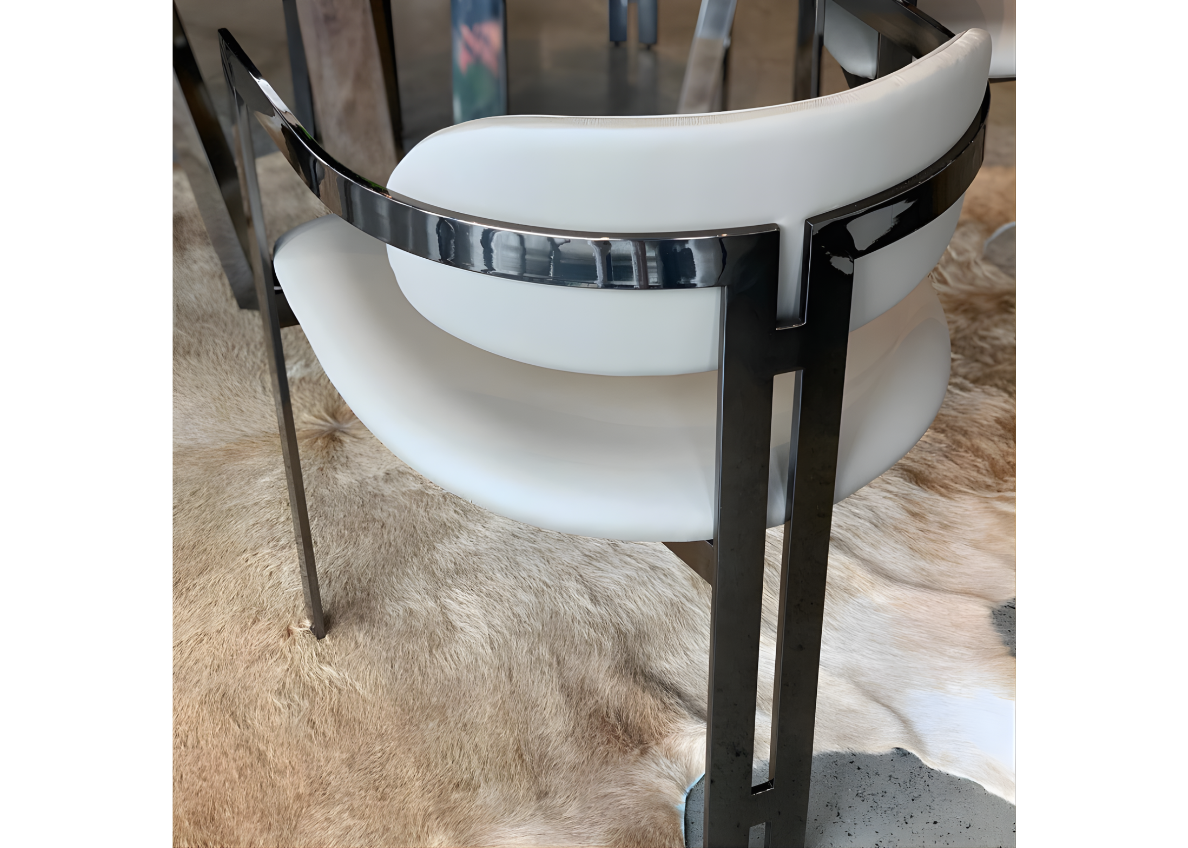 Cadeira Calla com base em aço inox e revestimento em couríssimo off-white, oferecendo elegância, conforto e sofisticação ao ambiente.