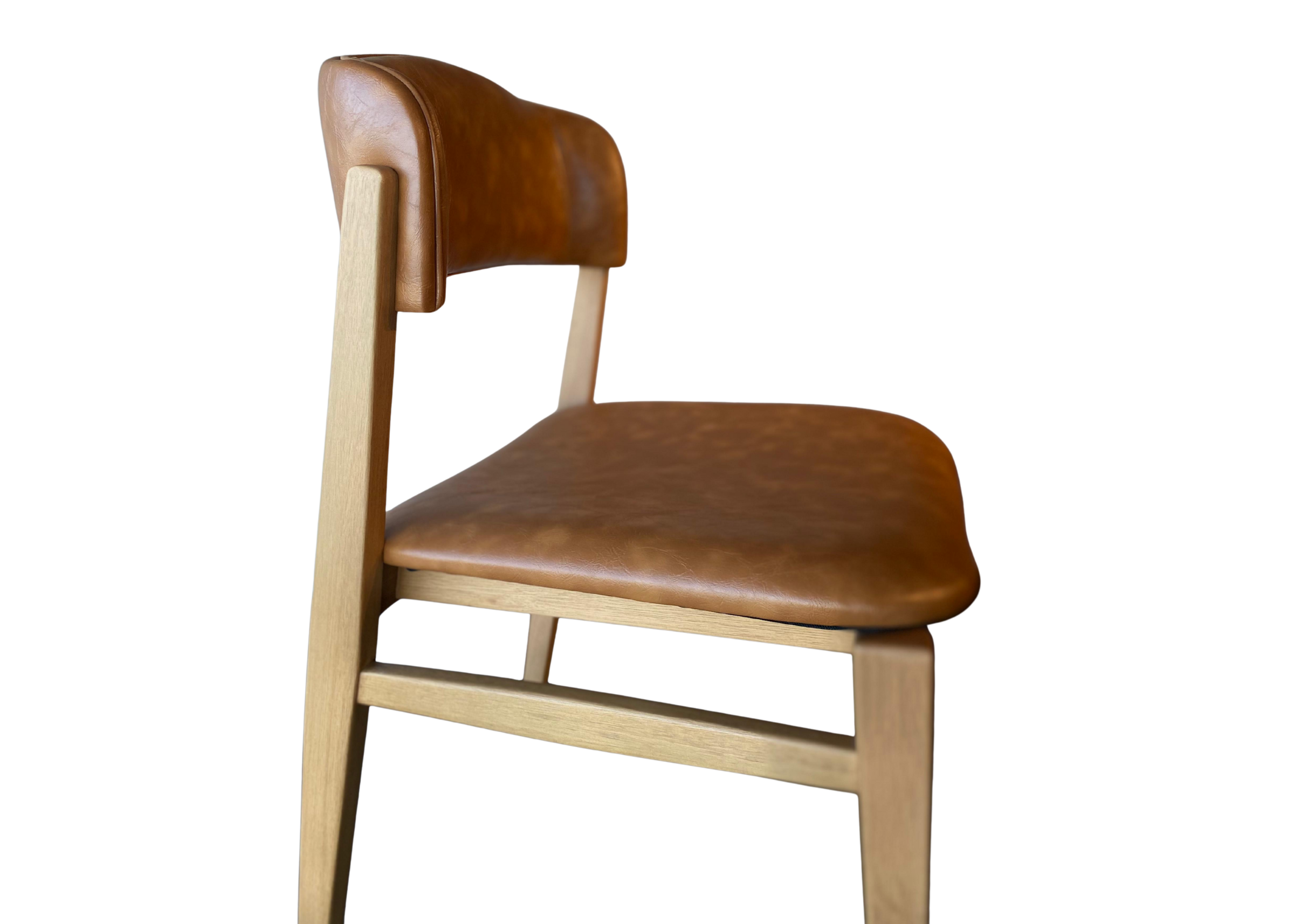 Cadeira com detalhes em tecido couríssimo caramelo, oferecendo conforto, elegância e um toque sofisticado à decoração.