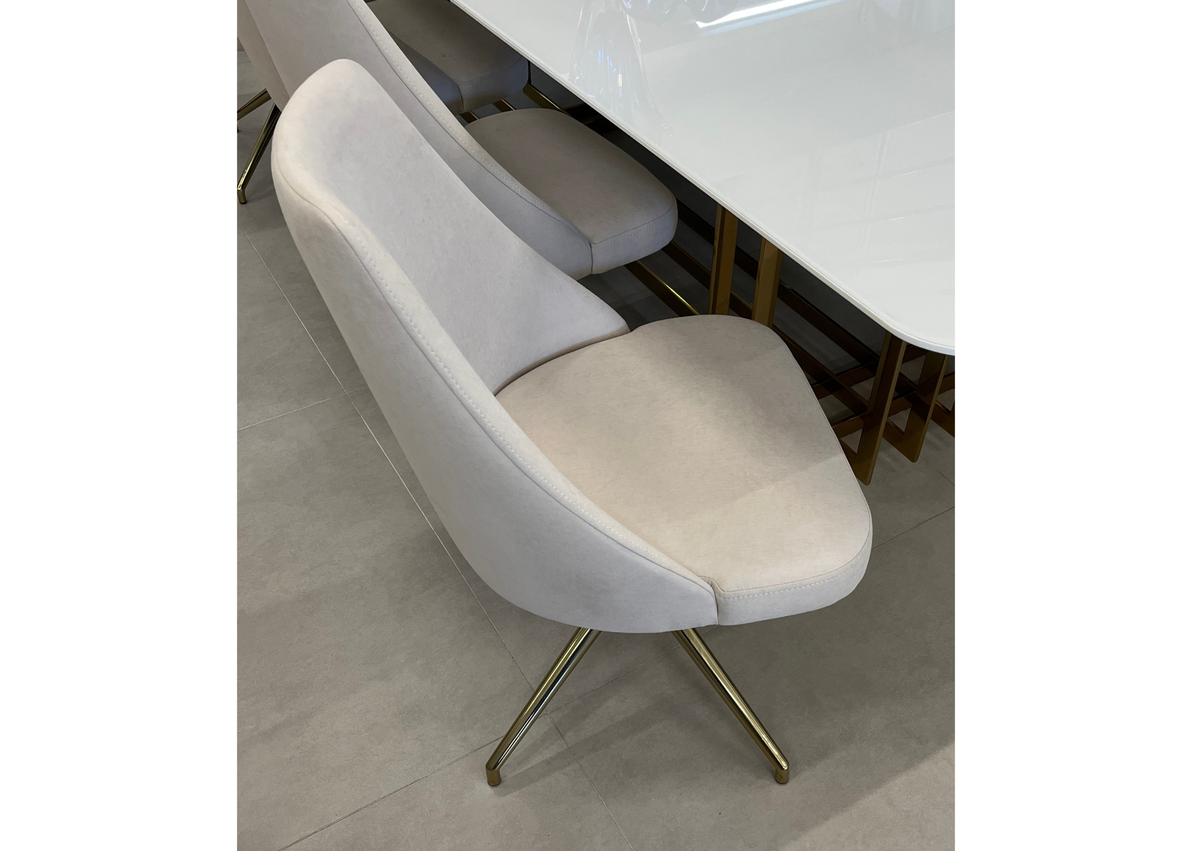 Cadeira giratória Adelle estofada em veludo off-white com base dourada. Móvel sofisticado e elegante para salas de jantar ou escritórios modernos.