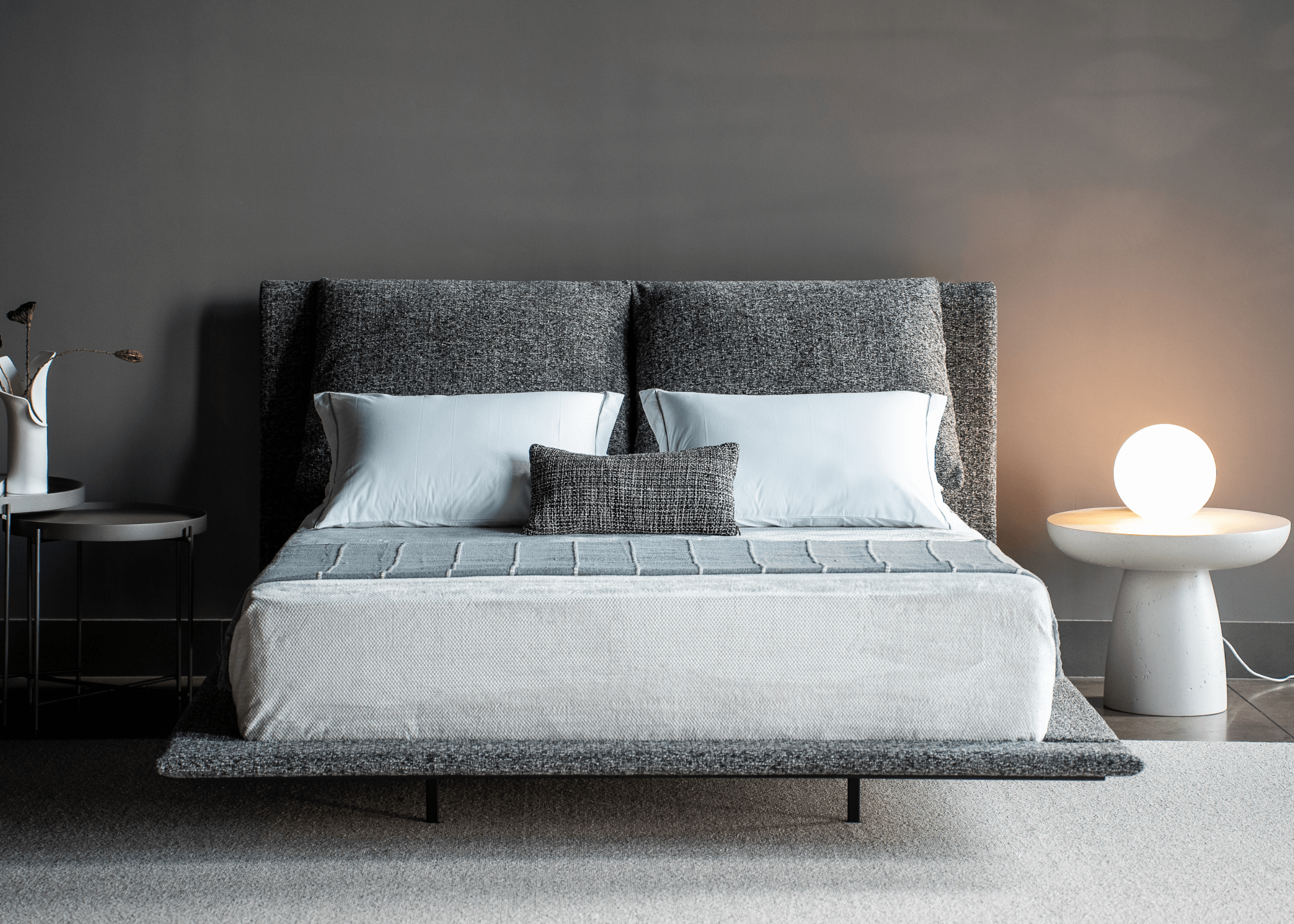 Cama Clara estofada em tecido texturizado com cabeceira dupla e estrutura metálica, design moderno para quartos sofisticados.