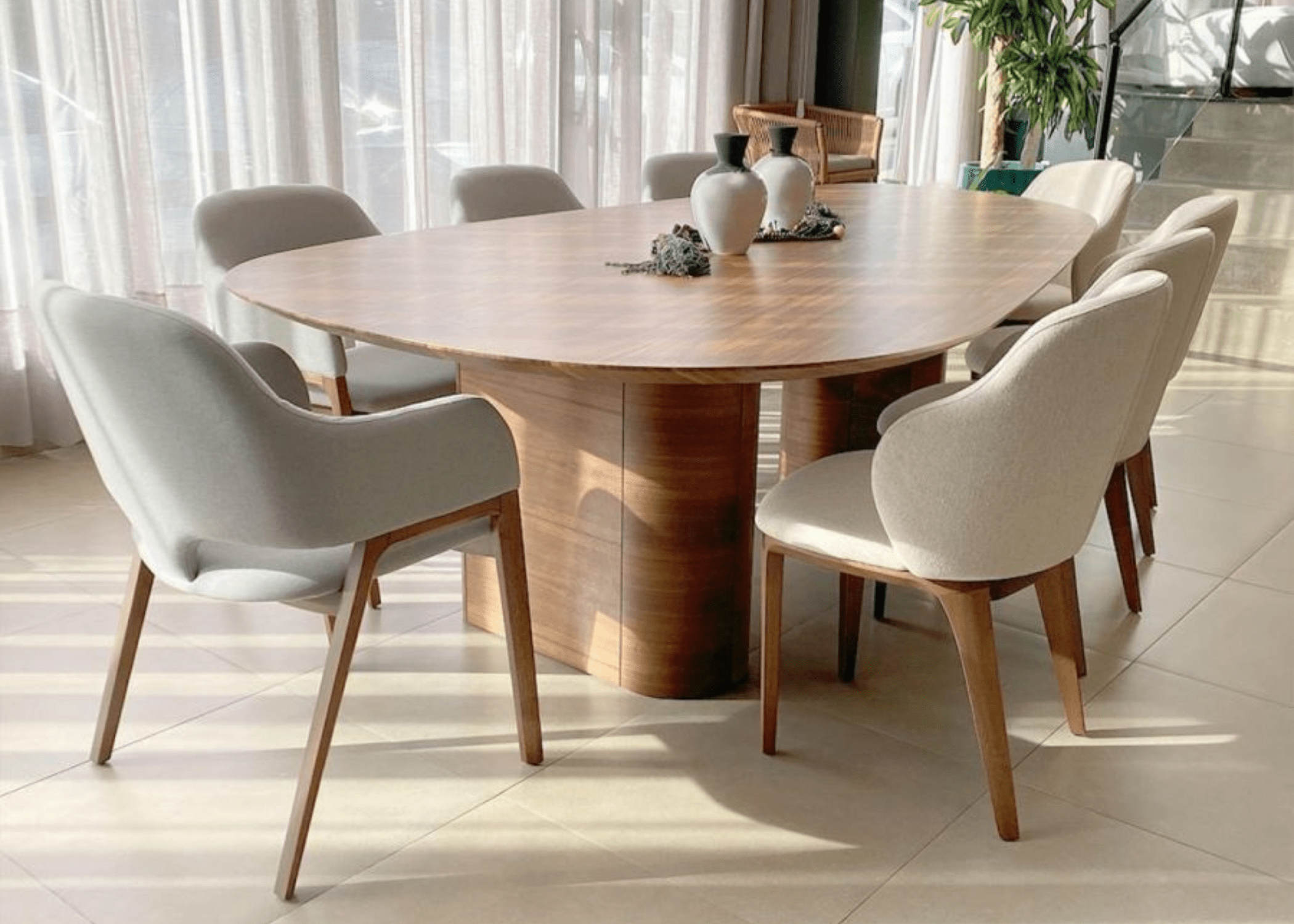 Mesa de Jantar Orgânica Artemis em sala moderna, com tampo curvado e base elegante, criando um ambiente sofisticado.