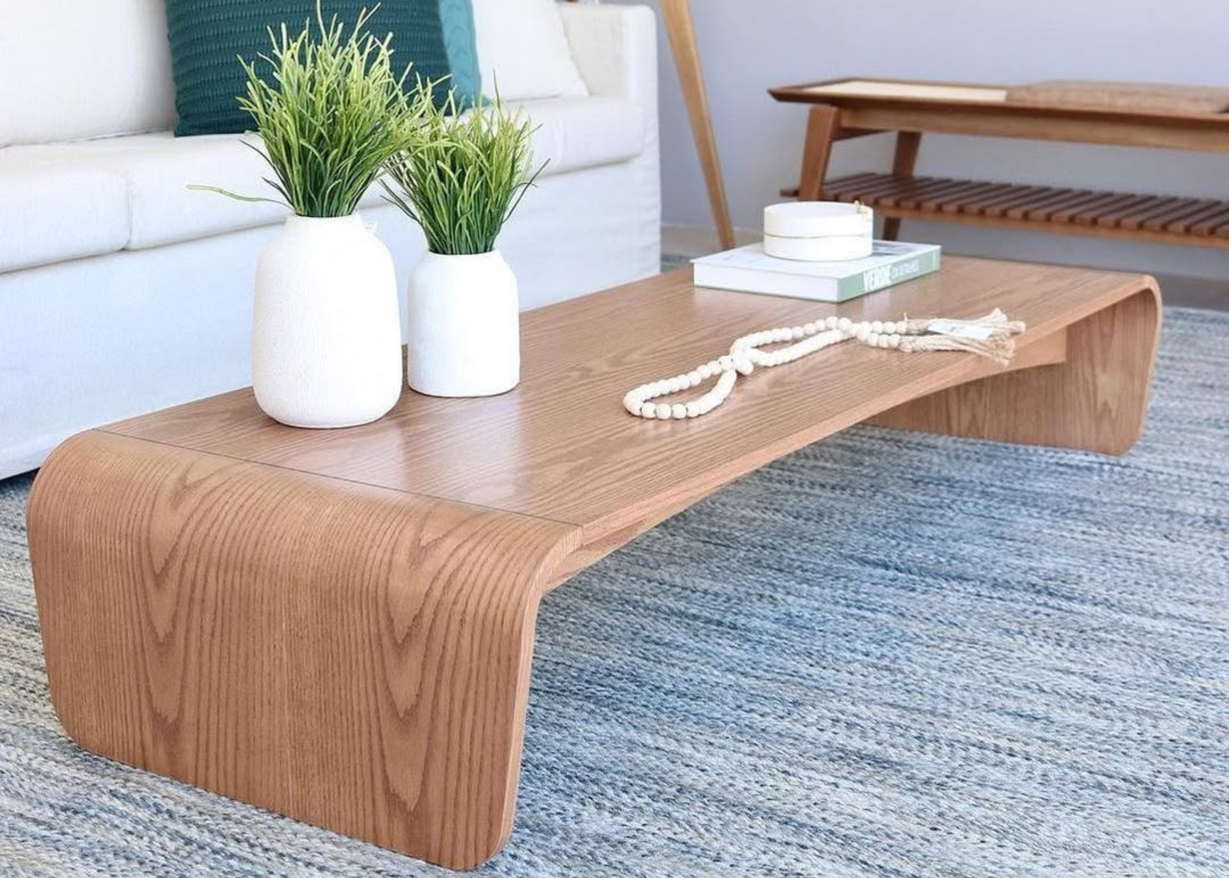 Mesa de centro Laura com acabamento laminado, vista em ambiente interno. Design contemporâneo com linhas suaves, ideal para compor salas de estar elegantes.