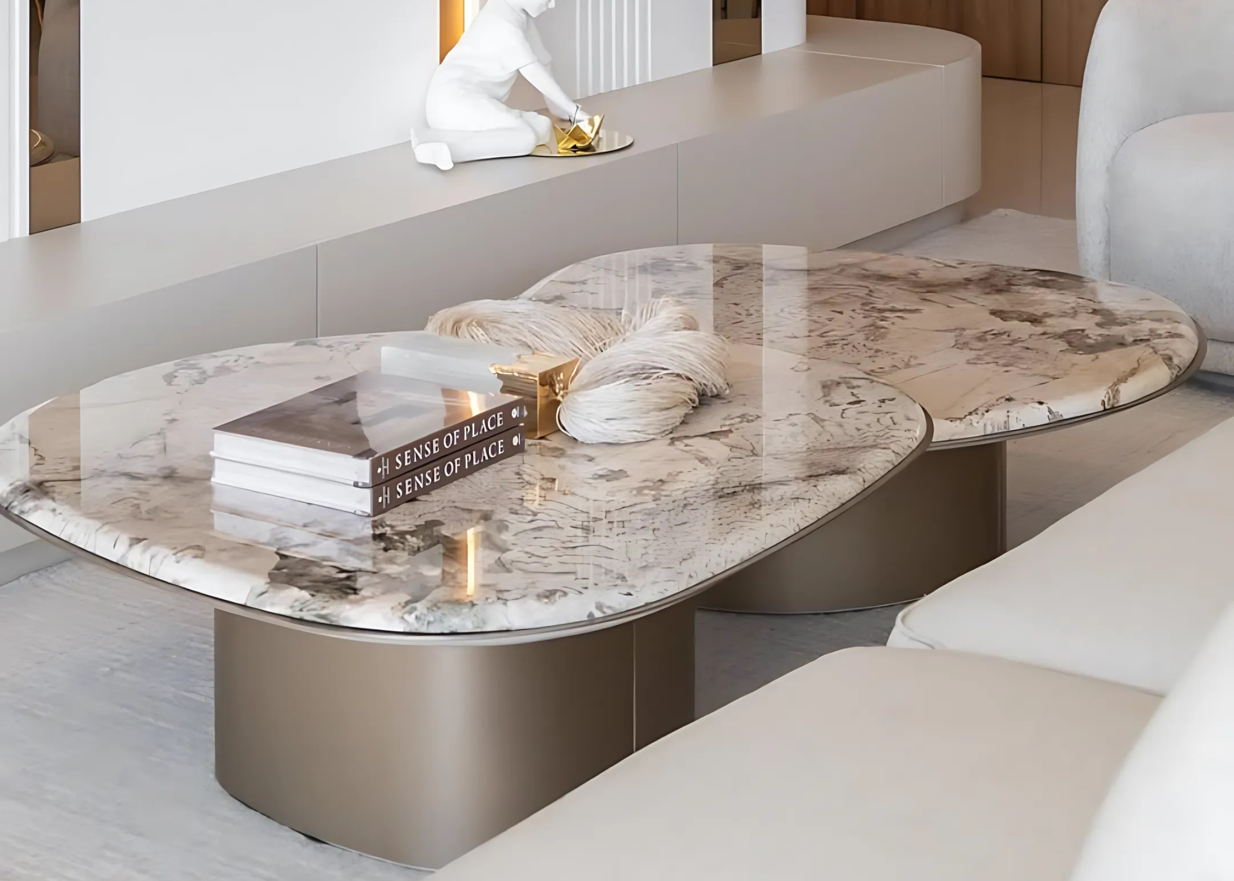 Mesa de centro Majestosa com tampo em mármore Alpinus e base metálica dourada, vista em sala de estar sofisticada. Móvel imponente e refinado para ambientes de alto padrão.