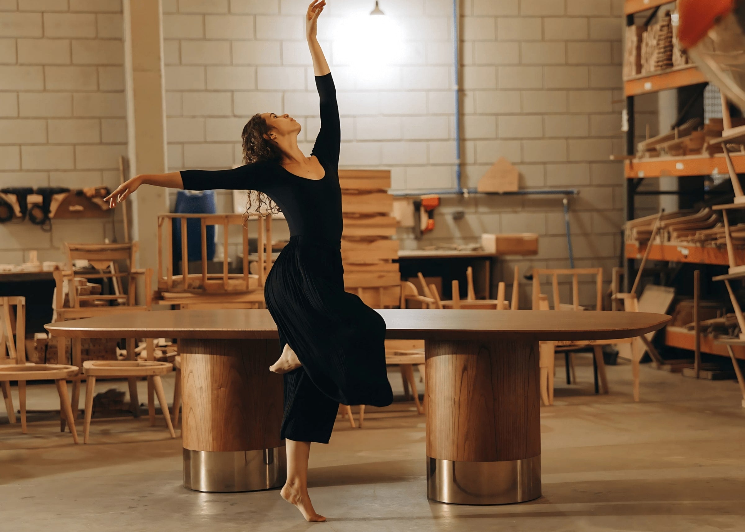 Mesa de jantar Heron em ambiente industrial com design escultural e base cilíndrica metálica – expressão de elegância e presença visual.