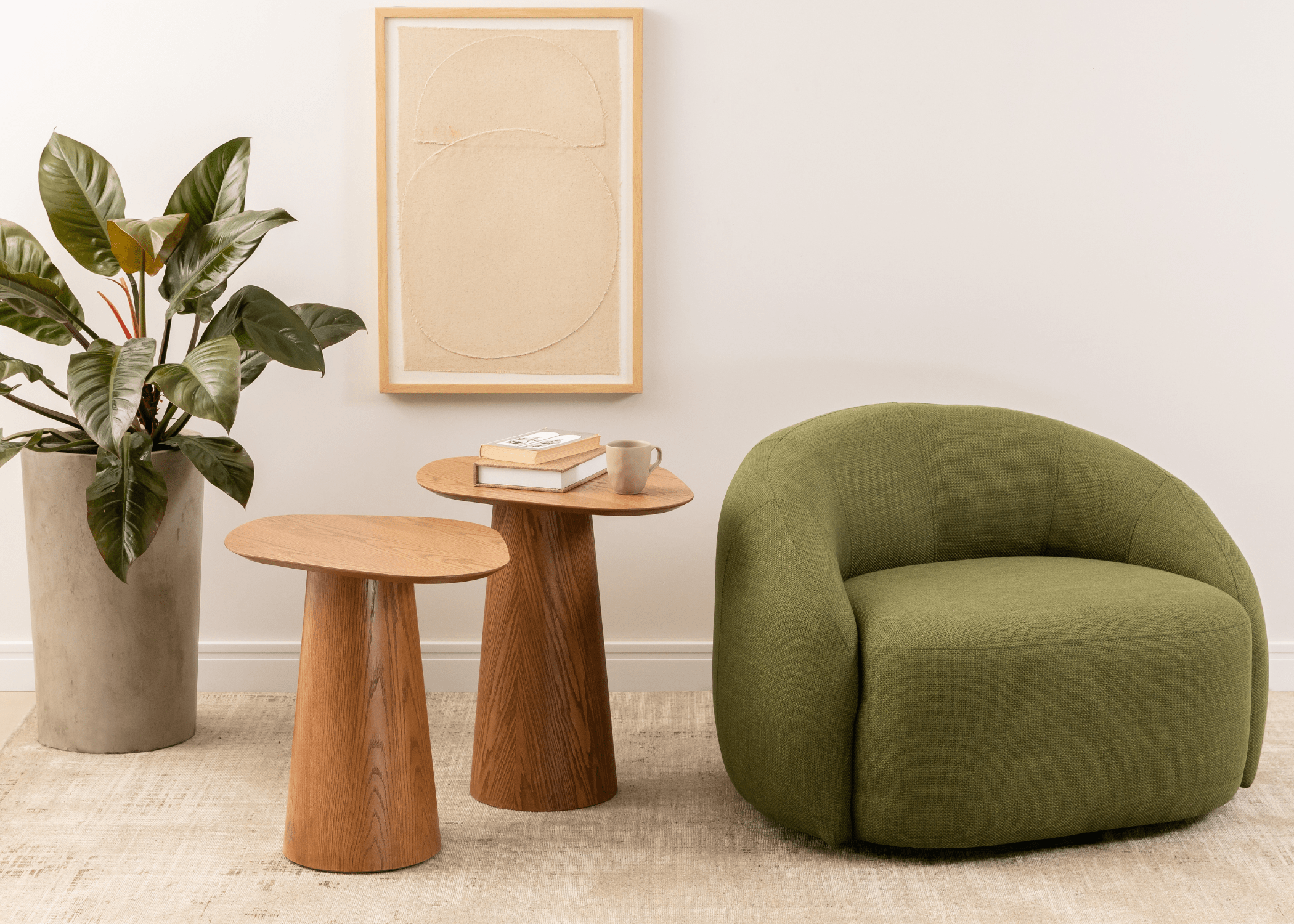 Mesa lateral de madeira Raiver ao lado de poltrona verde em sala contemporânea.