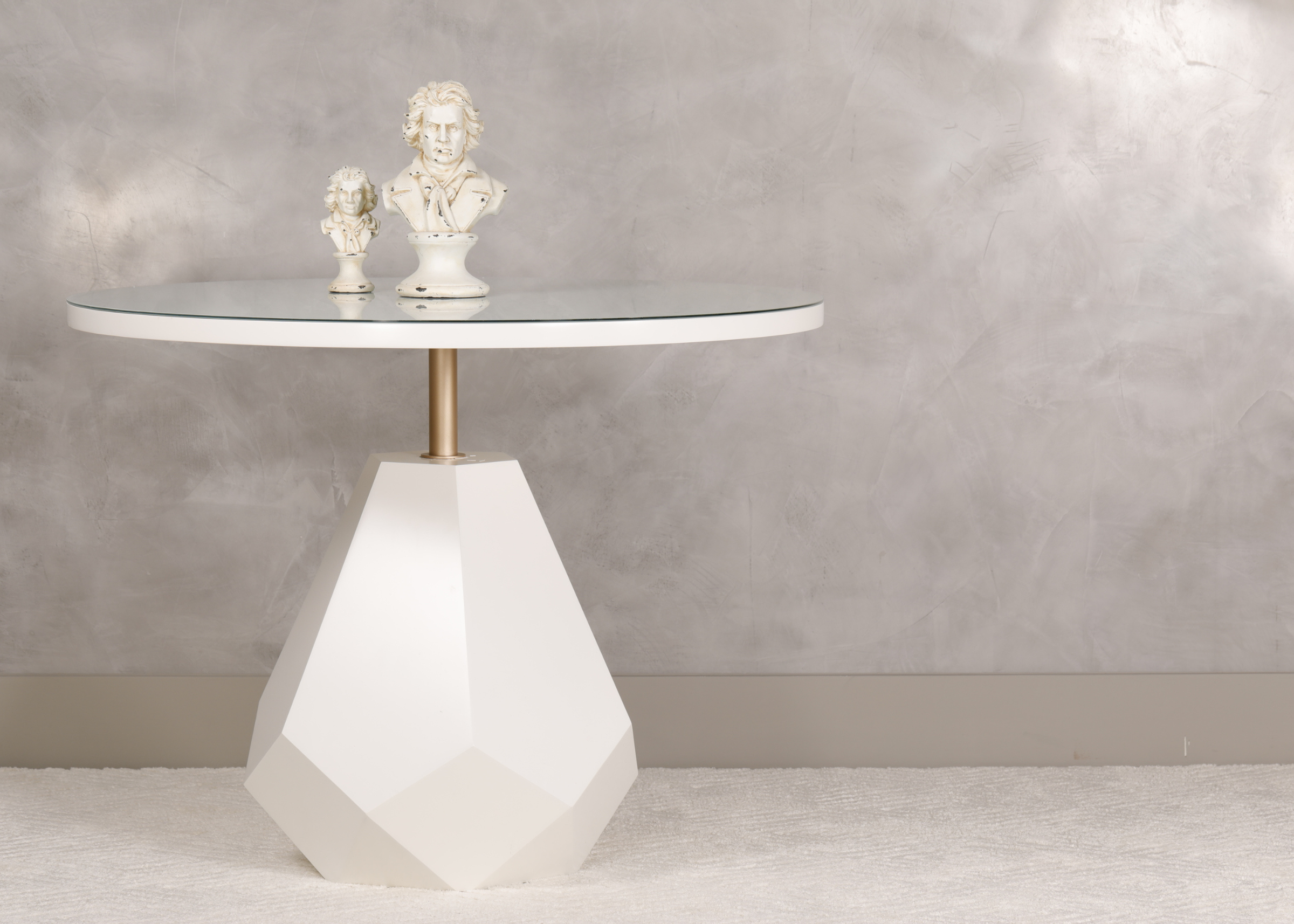 Mesa lateral redonda modelo Âmbar, em laca branca com base escultural e haste dourada, design elegante e contemporâneo, ideal para salas de estar sofisticadas.