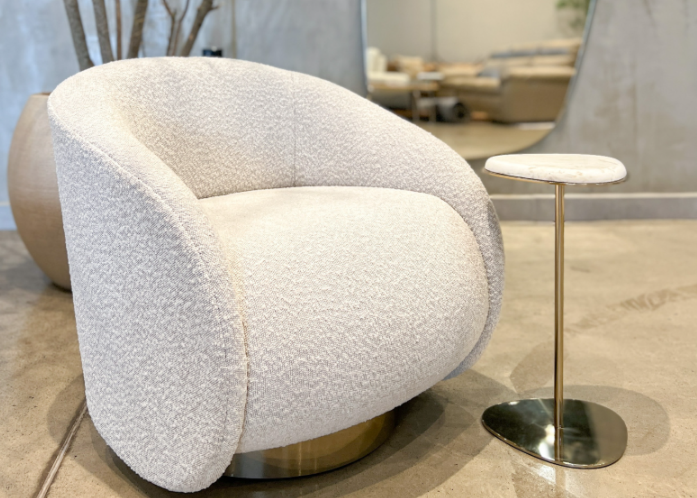Poltrona Calla elegante em tecido boucle off-white, combinando conforto, sofisticação e estilo contemporâneo para a sala de estar.