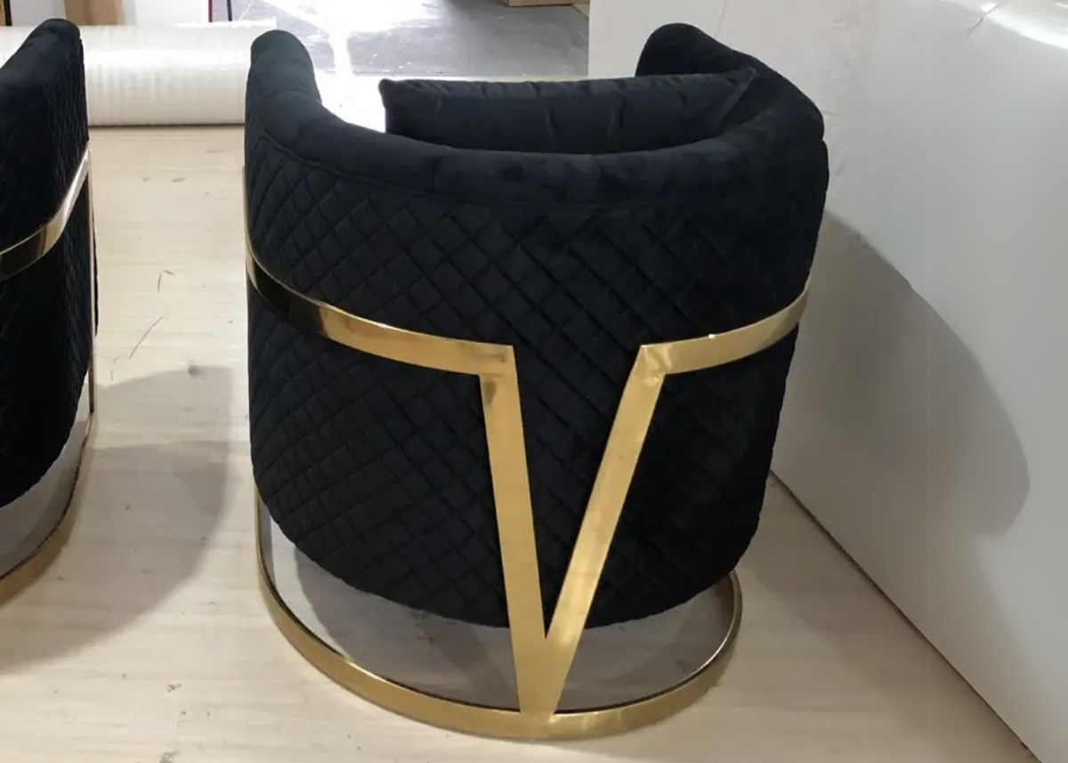 Poltrona Versace com detalhe em formato de "V" nas costas e estrutura refinada. Design elegante e marcante, ideal para ambientes sofisticados e contemporâneos.
