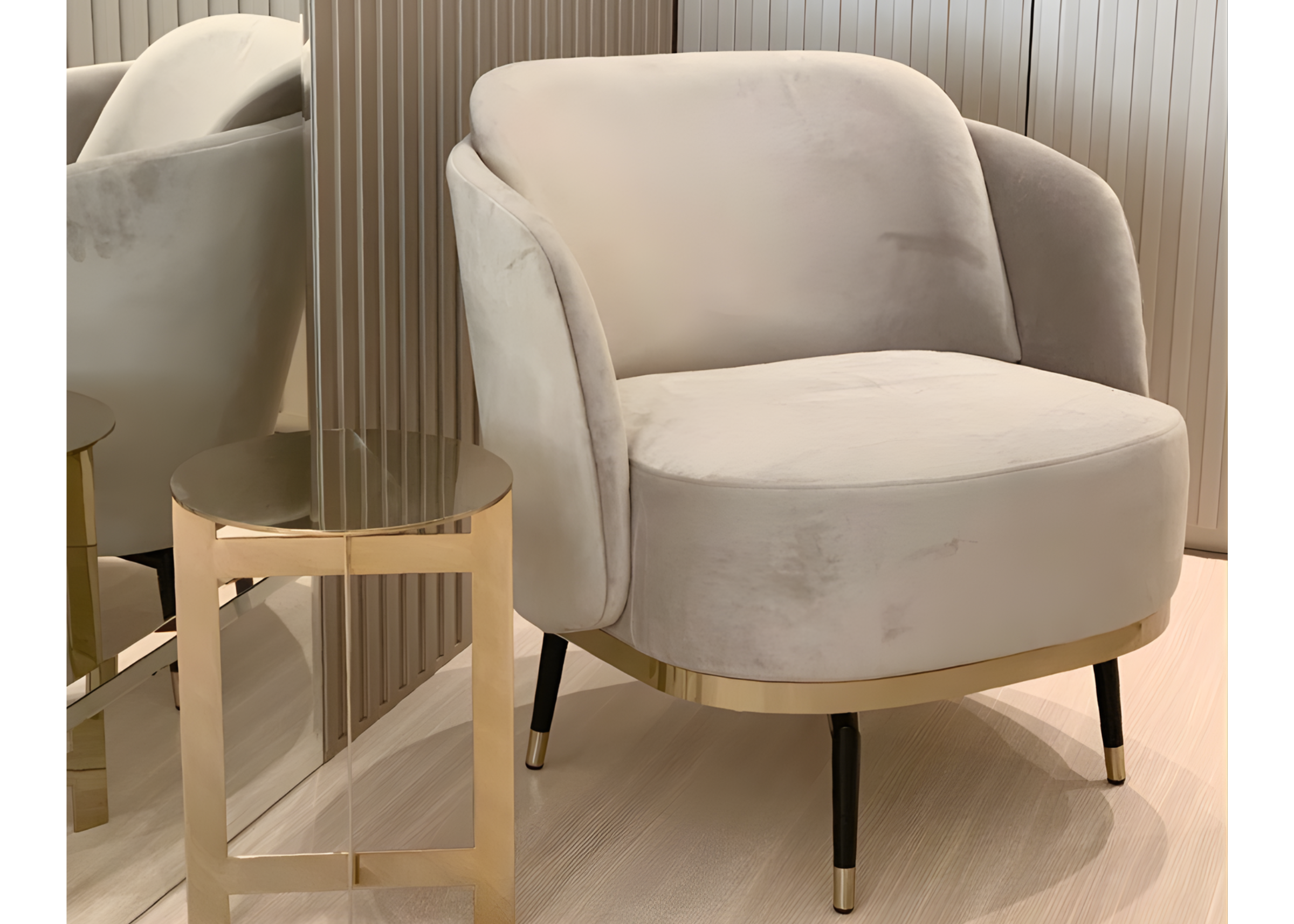 Poltrona Havena com estofamento em tecido veludo off-white e base dourada, combinando luxo, conforto e elegância no ambiente.