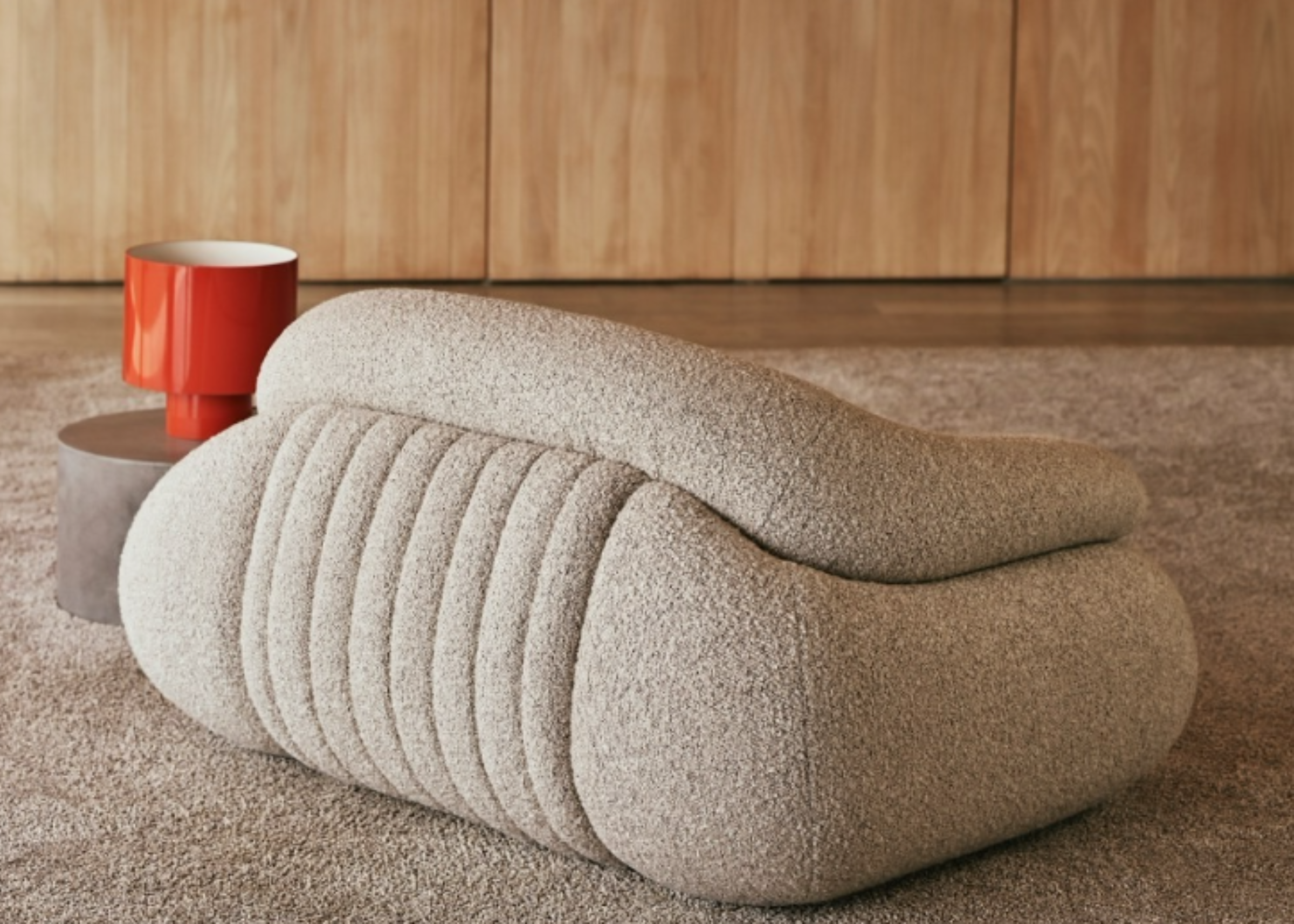 Poltrona Jubarte com costas e detalhes marcantes em sala de estar sofisticada, destacando design elegante e conforto acolhedor.