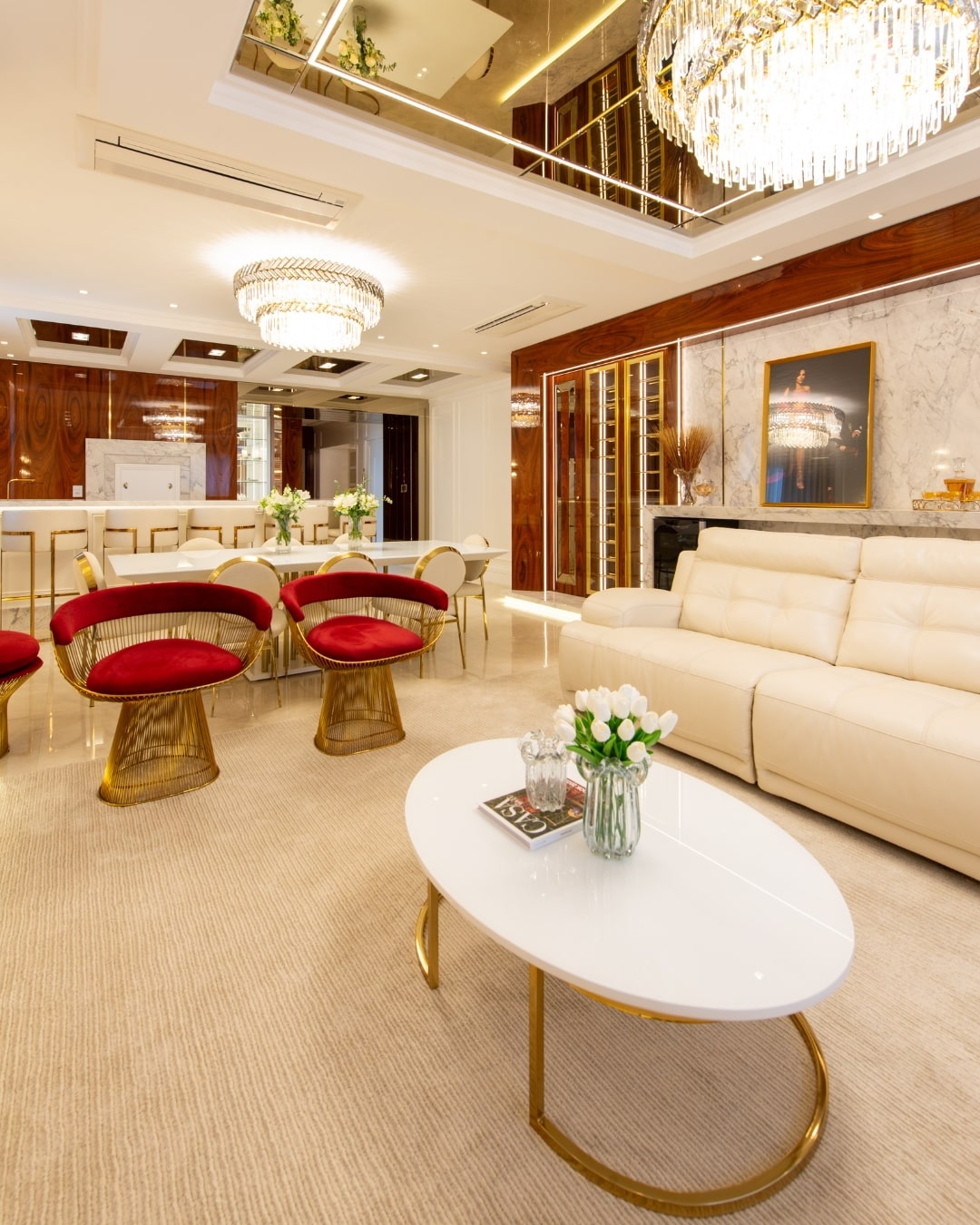 Sala de jantar sofisticada com cadeiras Platner em aço inox dourado e veludo vermelho, mesa de centro branca e poltronas Diamante gold – ambiente assinado por Larissa Ienerich com mobiliário exclusivo da Moveca Decor.