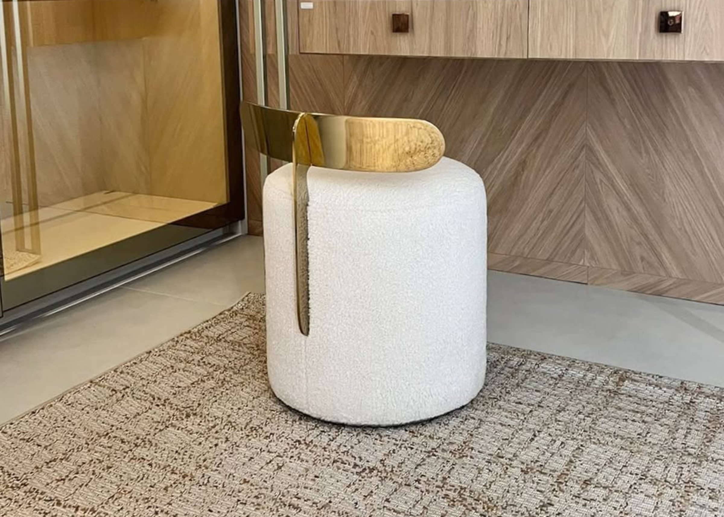 Puff redondo modelo Calla em tecido branco com base em inox gold. Design elegante e sofisticado para complementar ambientes modernos.