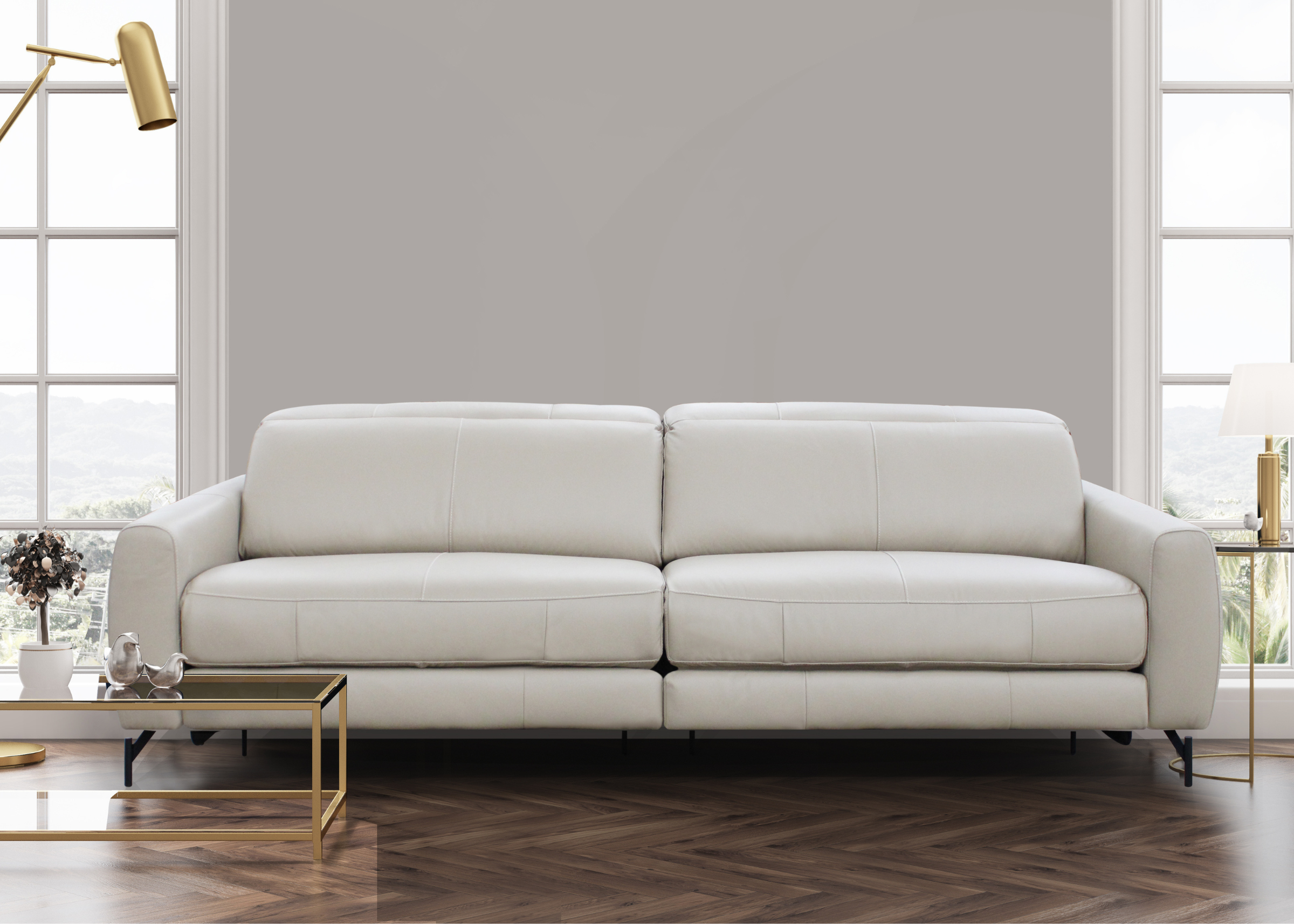 Sofá de dois lugares em couro natural, inserido em sala de estar moderna com decoração minimalista. Vista em perspectiva, destacando o design limpo e os pés metálicos.