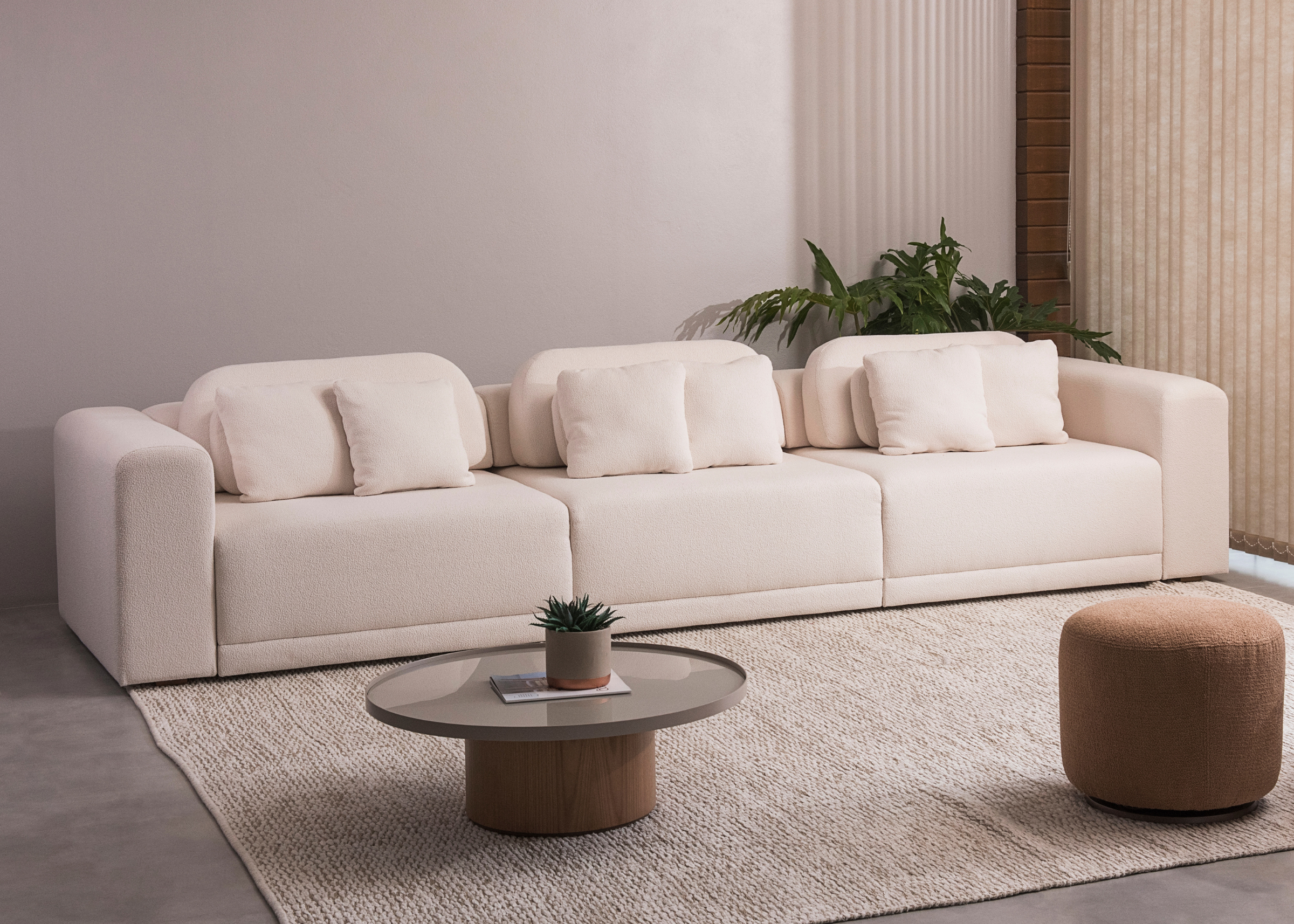 Sofá reclinável e retrátil com design moderno, revestido em bouclé off-white. Peça confortável e elegante, ideal para ambientes contemporâneos, apresentada sobre fundo neutro.