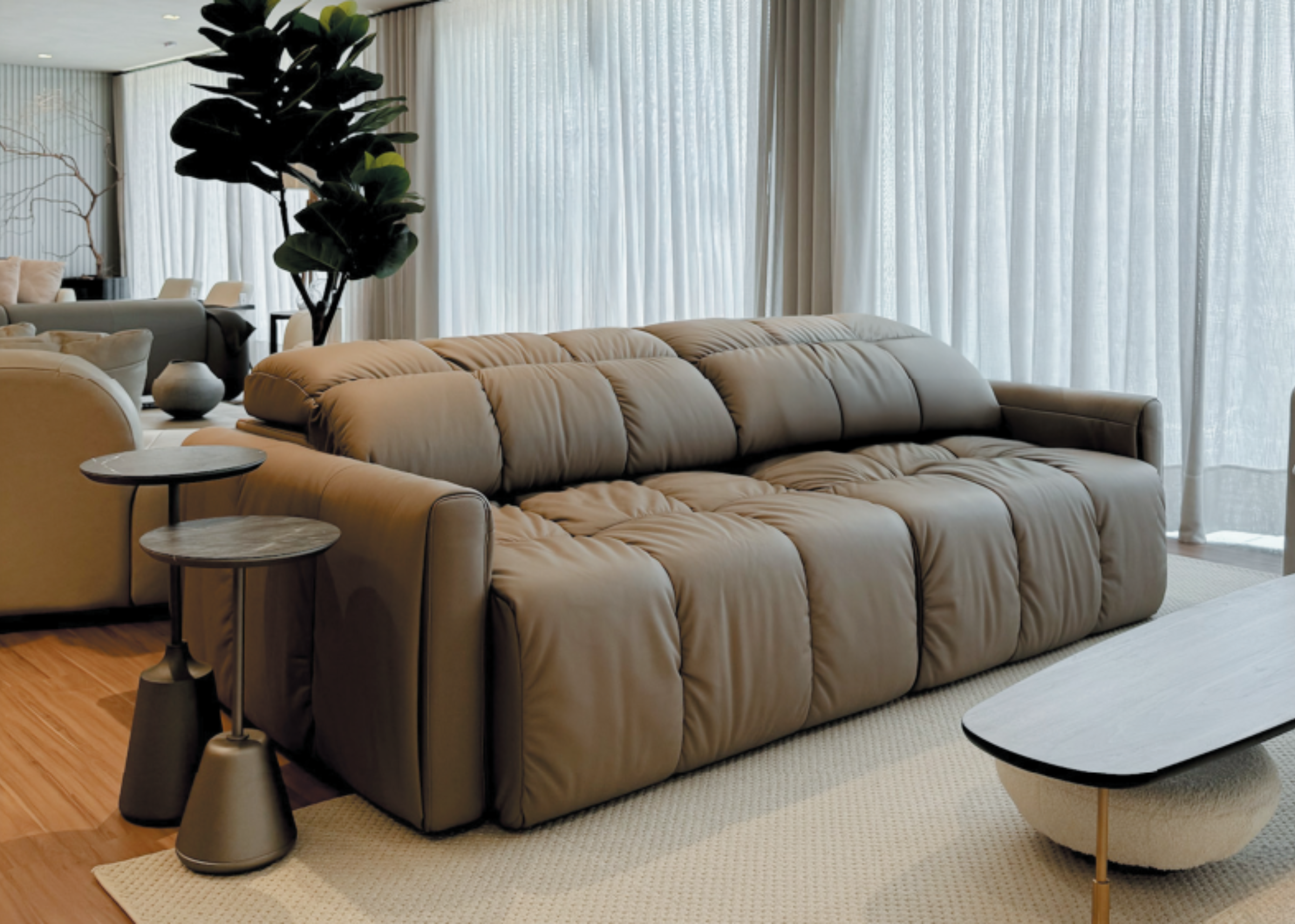 Sofá Santorini automatizado de dois lugares em couro natural, posicionado em sala de estar com decoração contemporânea. Design elegante com pés metálicos e acabamento refinado.