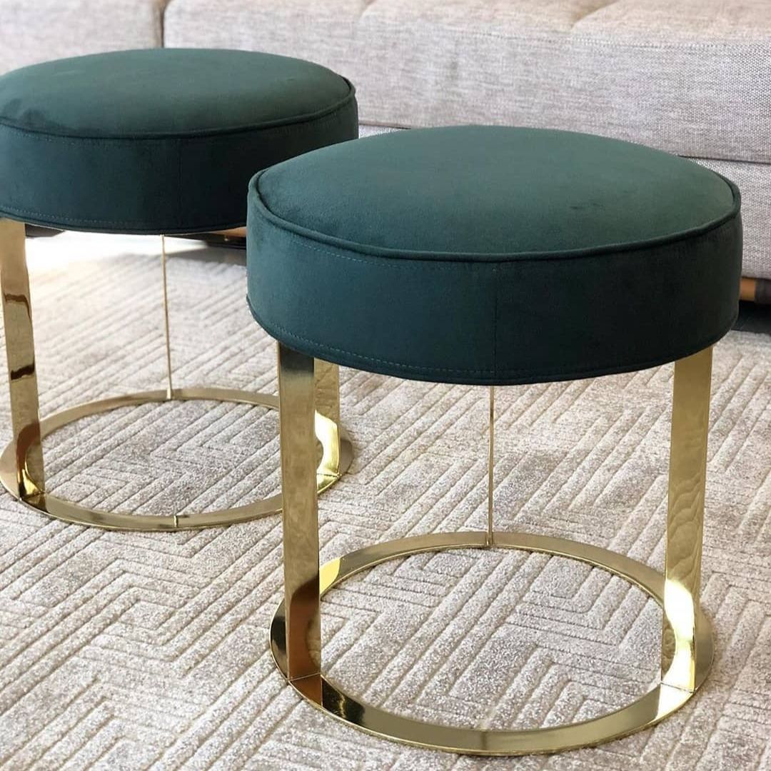 Puffs redondos dourados com base em inox gold e estofado veludo verde. Peças decorativas de luxo para salas de estar refinadas.