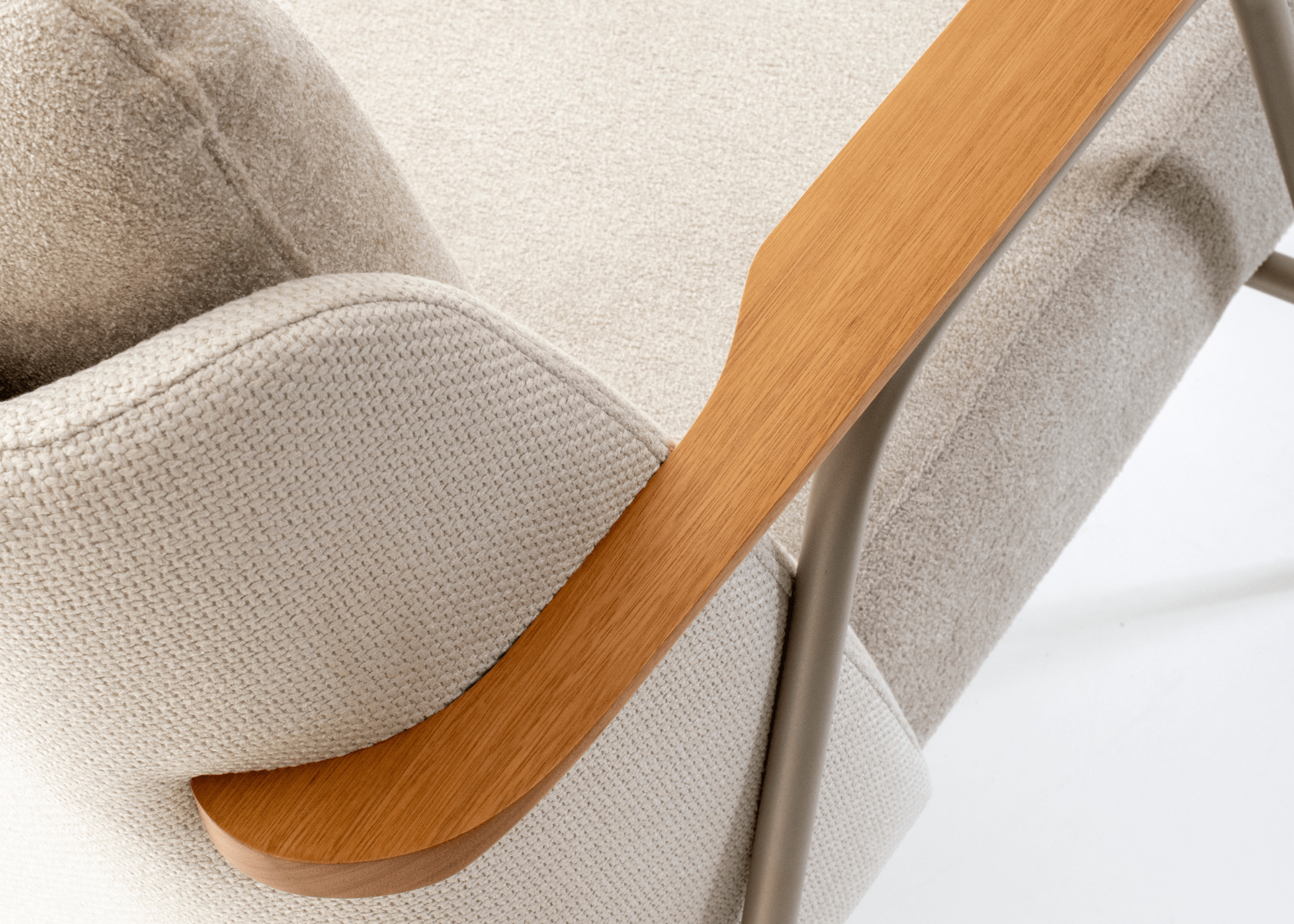 Detalhe dos apoios dos braços em lâmina de madeira na Poltrona Lancer, destacando sua rusticidade refinada.