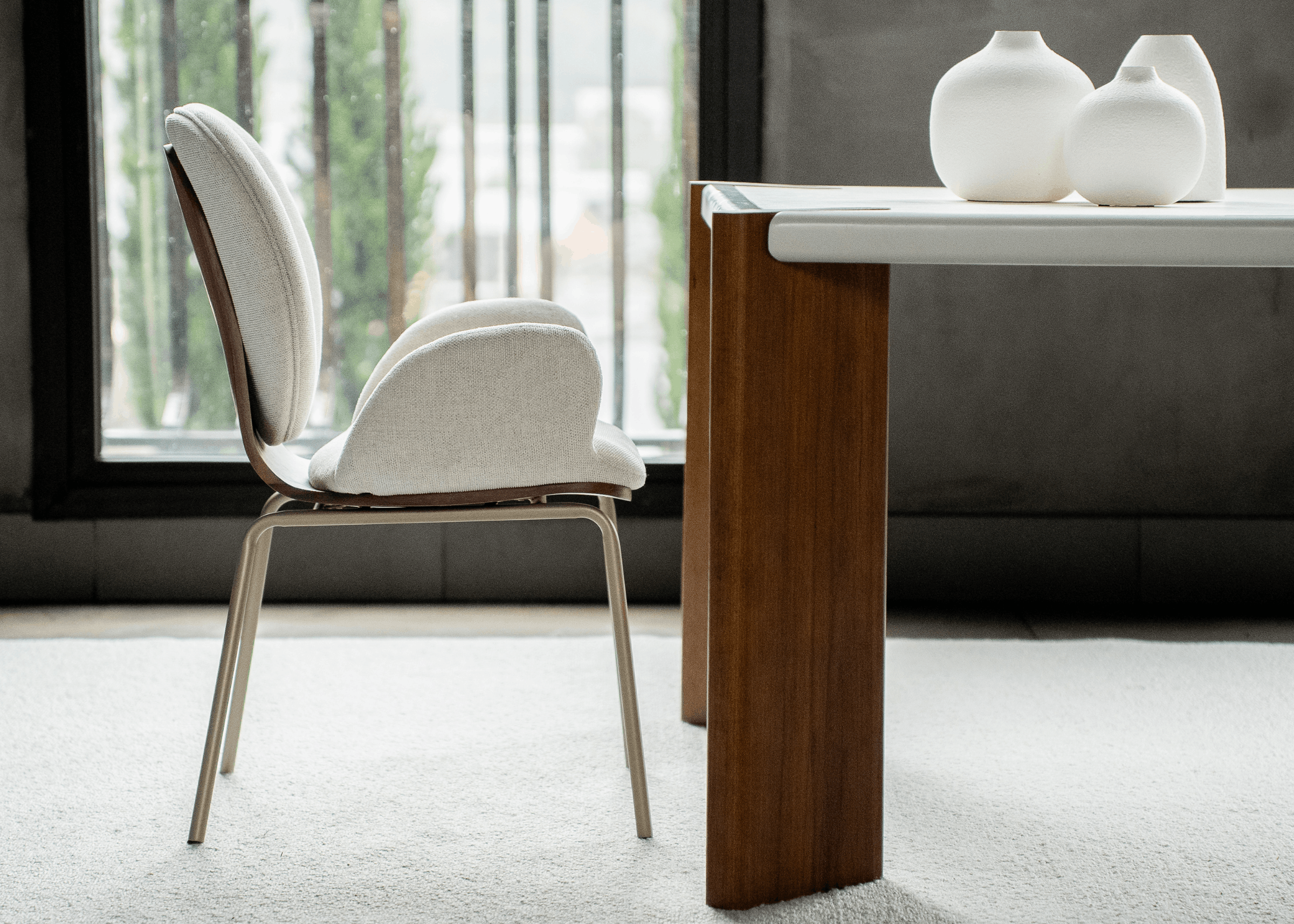 Cadeira Luidy compondo ambiente contemporâneo, estofado claro e estrutura metálica elegante.