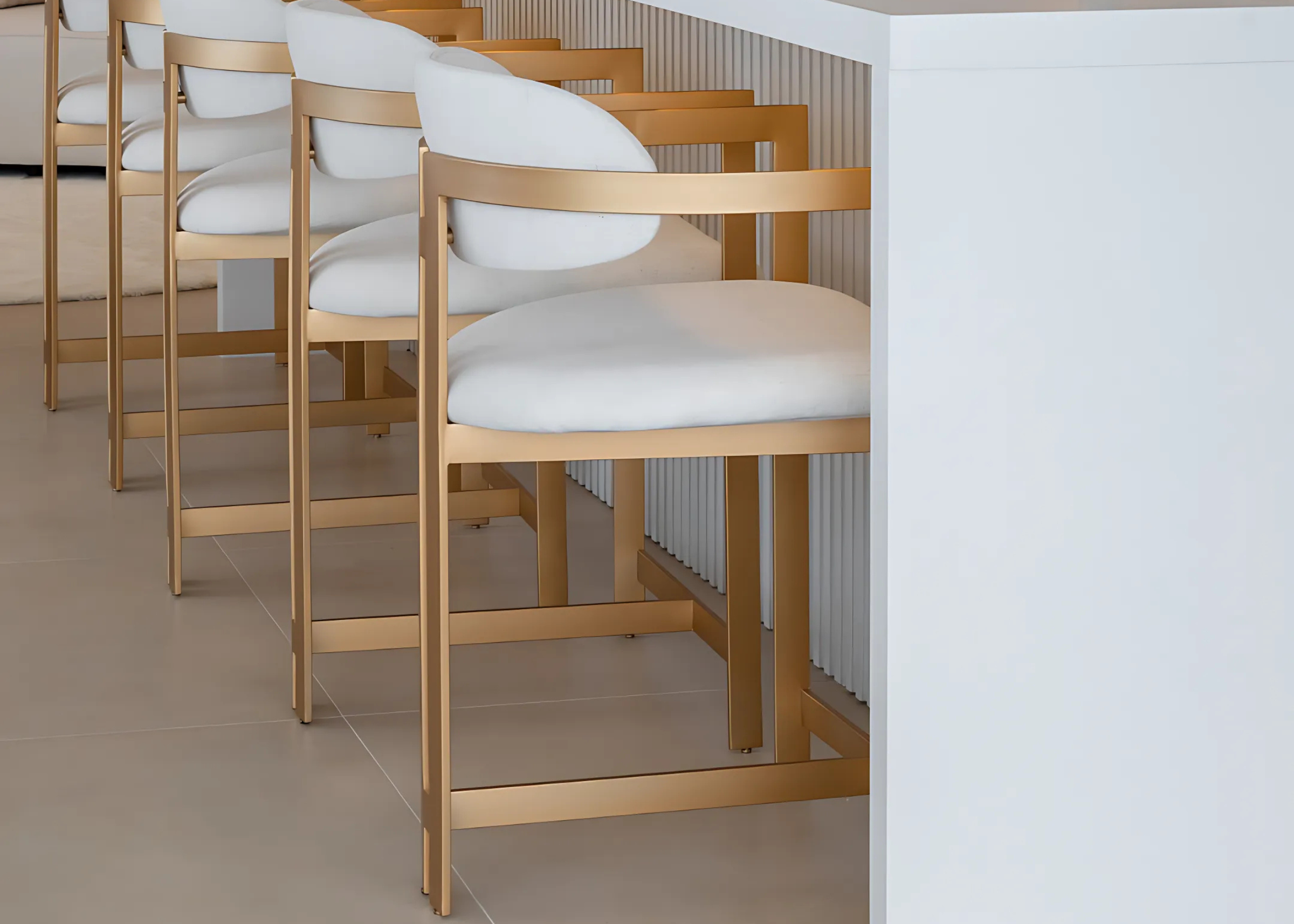 Banqueta Calla com base em inox dourado fosco, design moderno e sofisticado. Ideal para compor espaços contemporâneos e elegantes.
