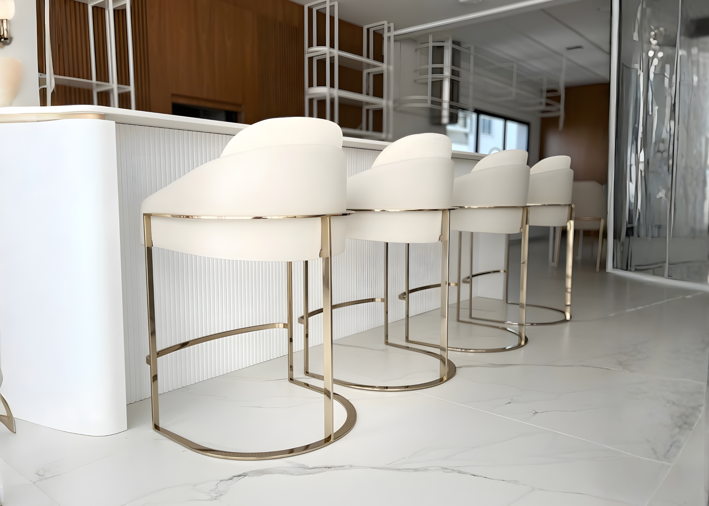 Banqueta Gatteo com estrutura em aço inox golden, apresentando design sofisticado e confortável, ideal para compor ambientes modernos e elegantes.