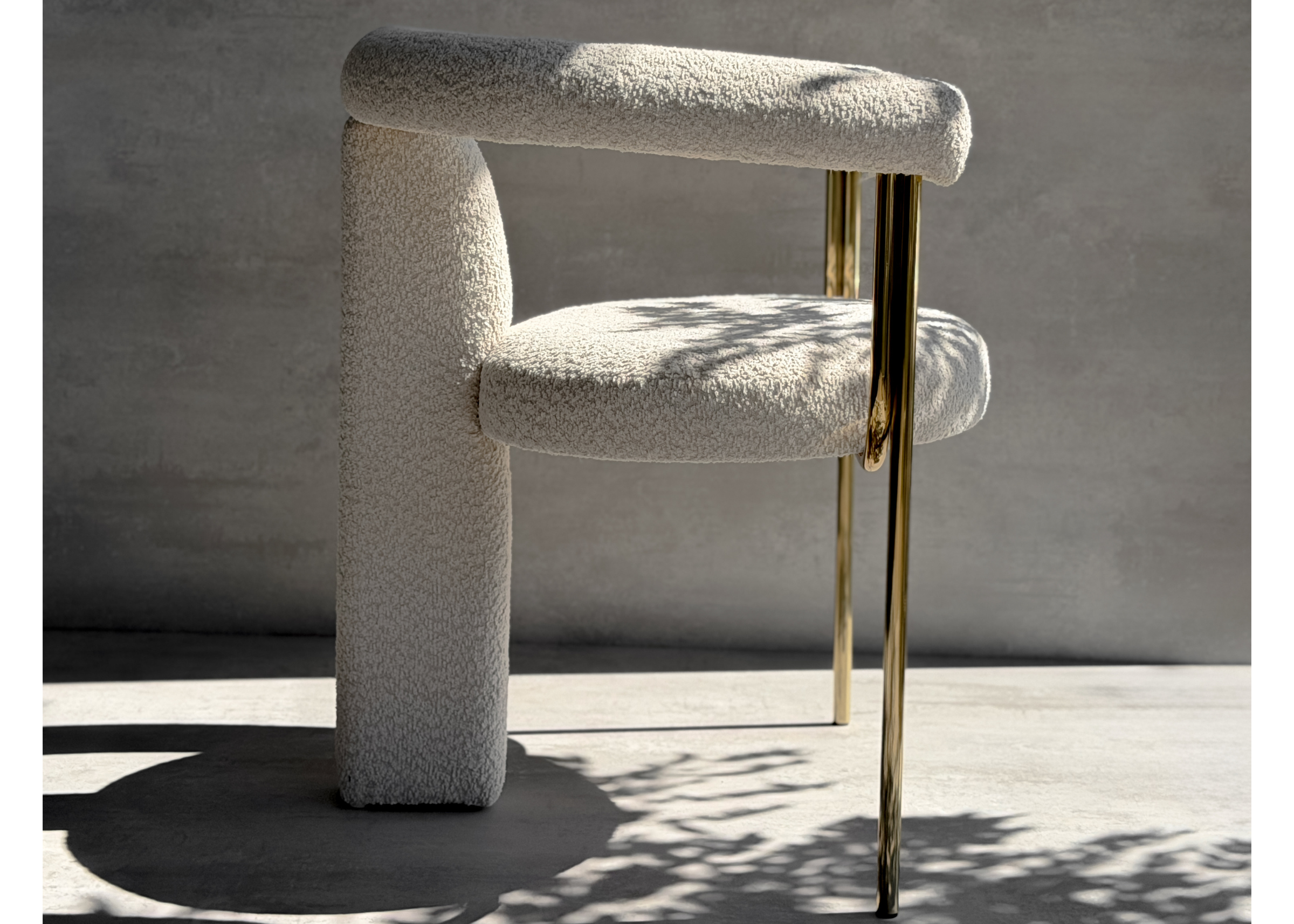 Cadeira Athos moderna com estrutura metálica dourada e revestimento bouclé off white, sofisticação e conforto visual.
