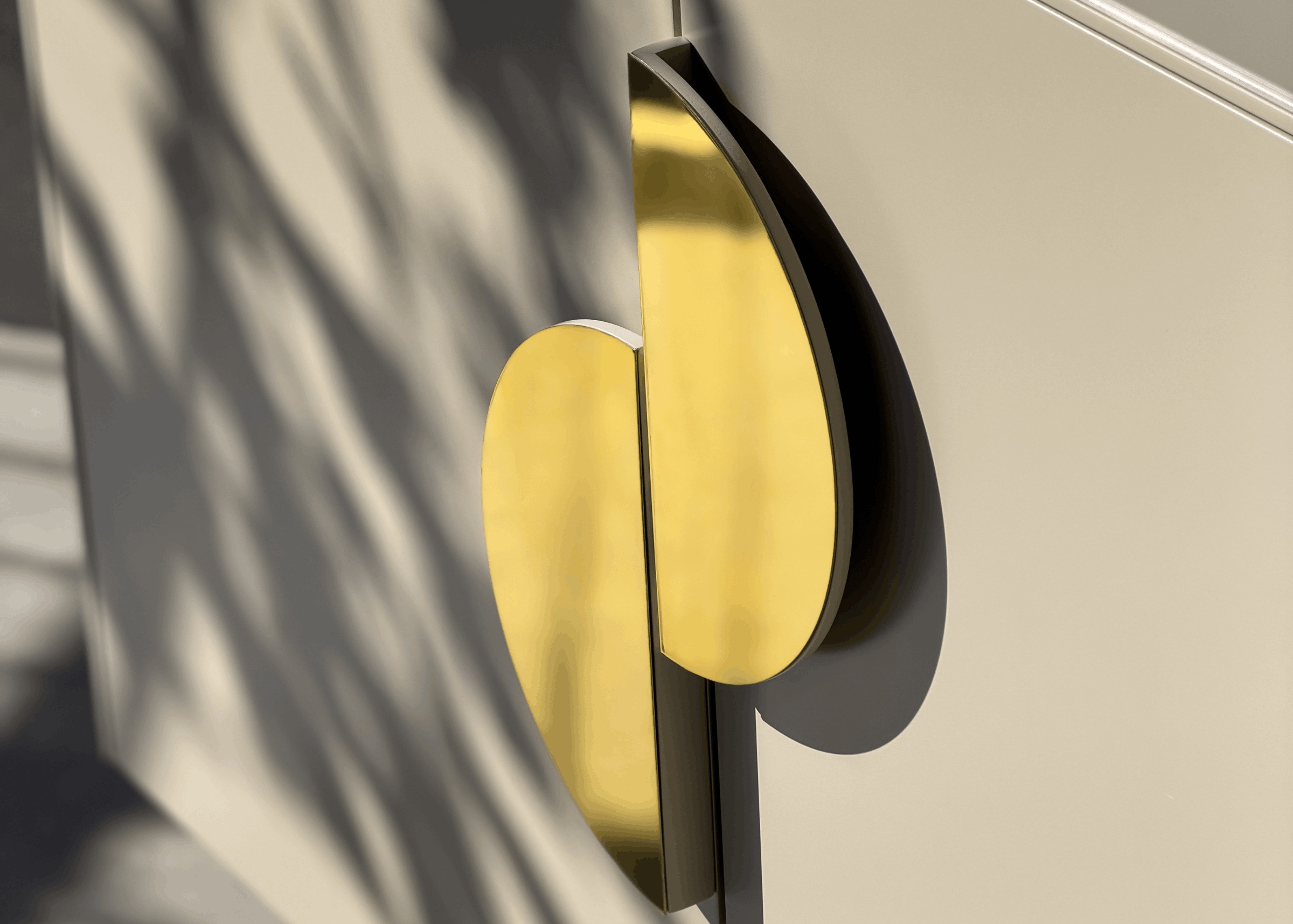 Detalhe do puxador dourado escultural da Cômoda Alba, elemento de design sofisticado que valoriza o visual contemporâneo do móvel.