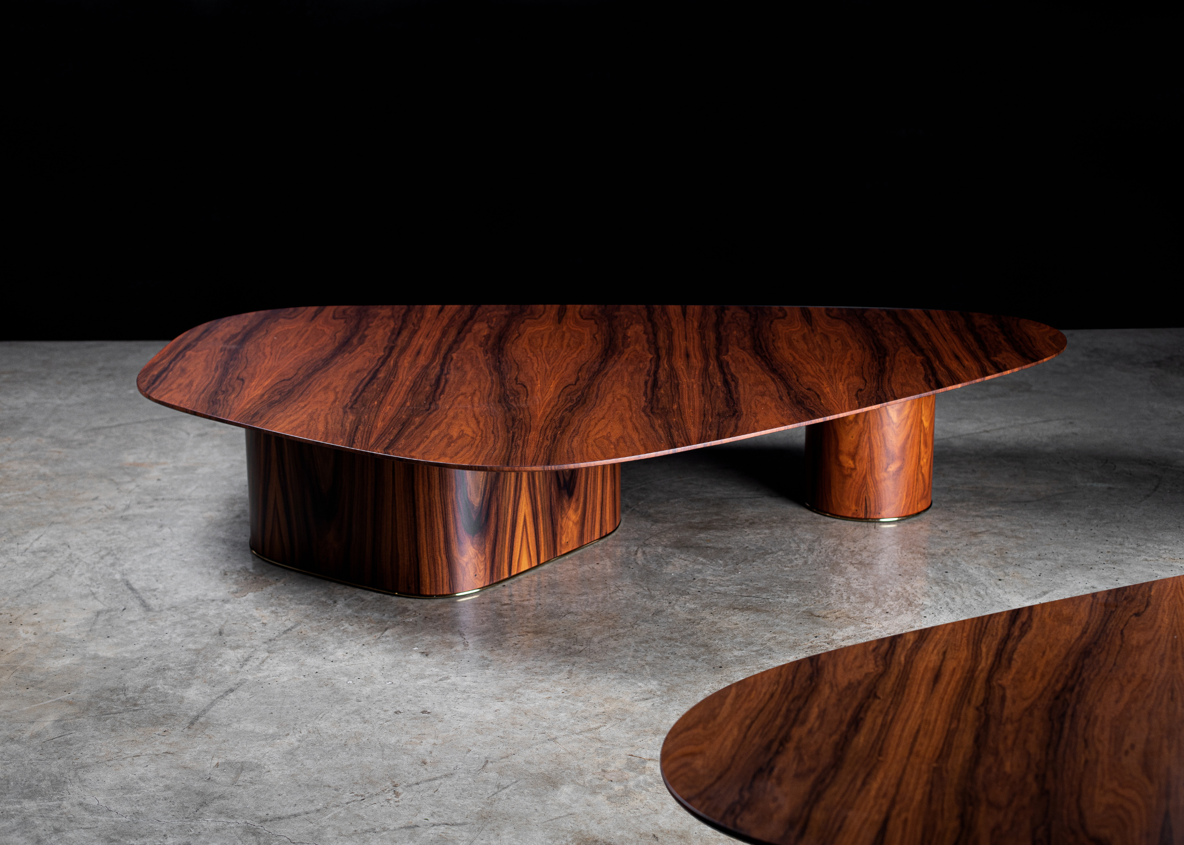 Mesa de centro orgânica modelo Delta em madeira pau-ferro. Design escultural e sofisticado para ambientes com estilo natural e contemporâneo.

