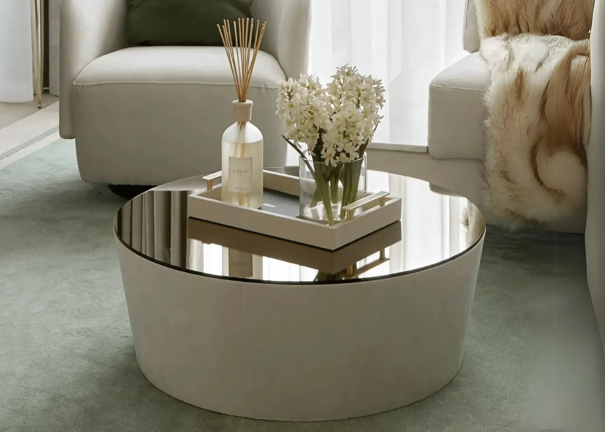 Mesa de centro redonda Bellatrix revestida em couríssimo, perfeita para salas de estar sofisticadas. Combinação de conforto e design moderno que valoriza ambientes contemporâneos com toque de elegância e durabilidade.