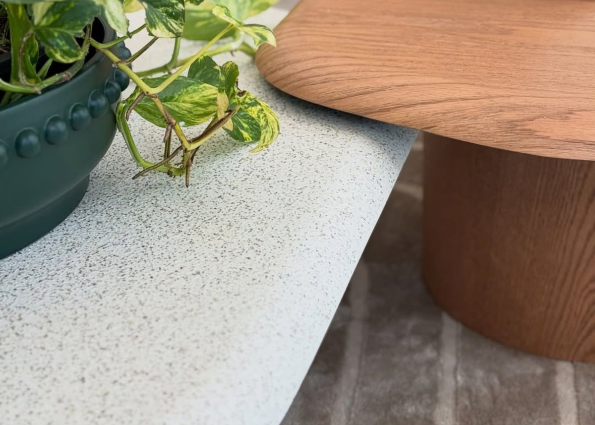Detalhe da Mesa de Centro Cora em lâmina de madeira, evidenciando os veios naturais e as bordas curvas do tampo