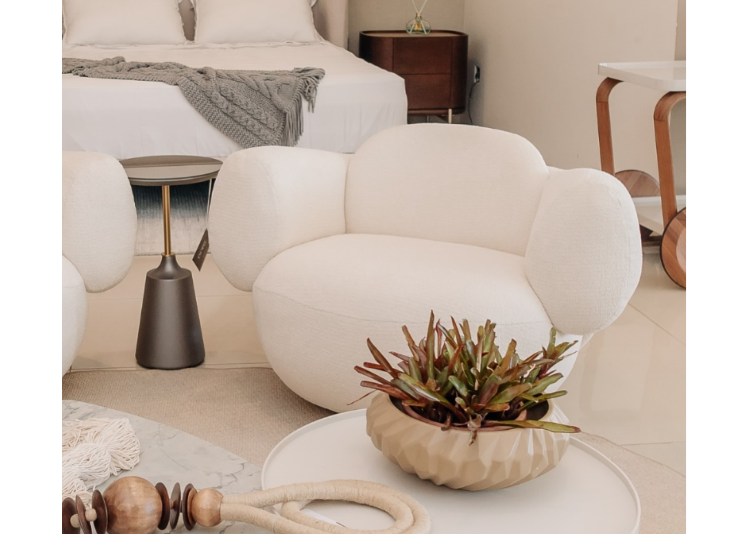 Poltrona Átria em sala de estar aconchegante, com detalhes modernos e revestimento em tecido off white, unindo conforto e elegância.