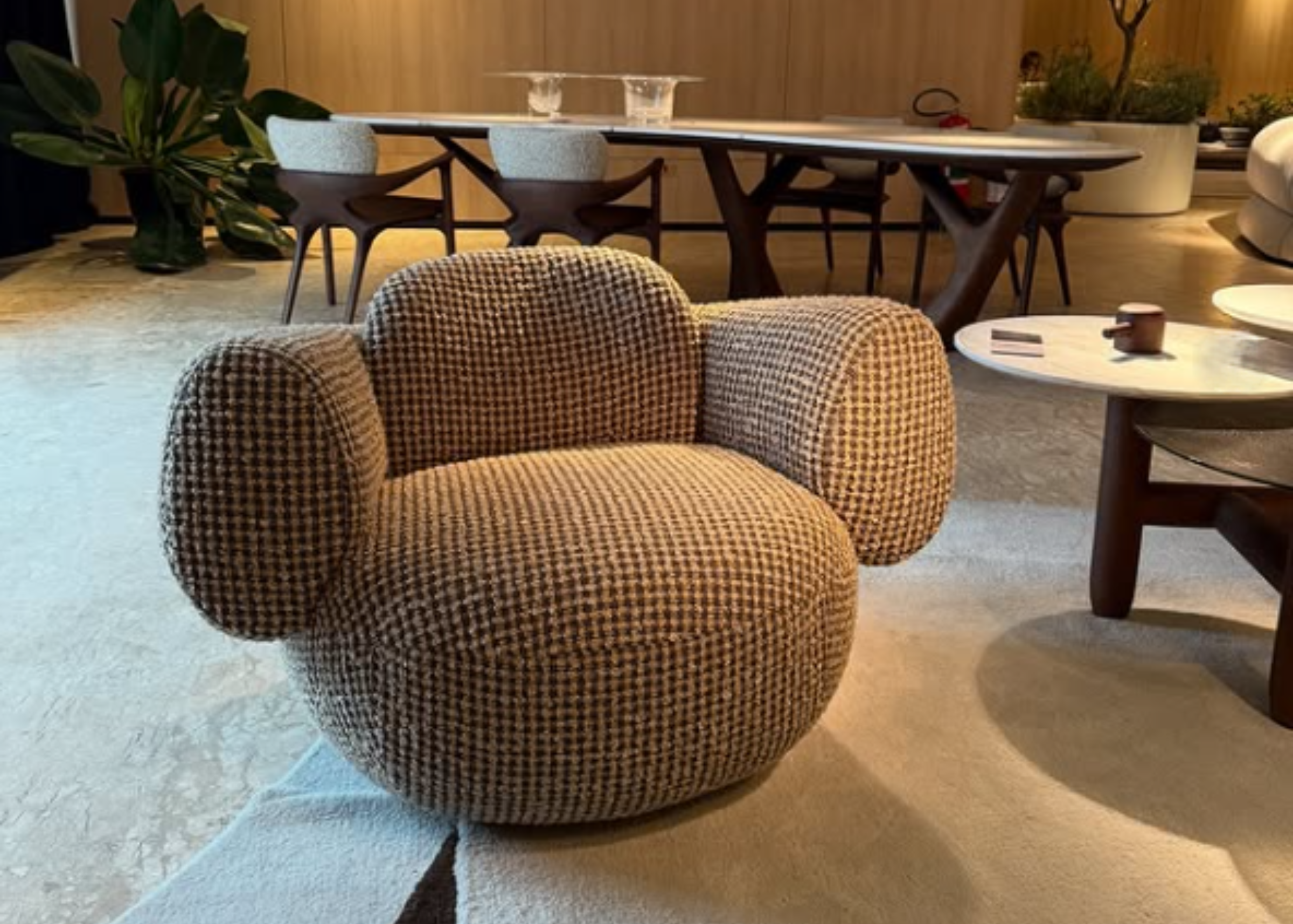 Poltrona Átria em sala de estar moderna e elegante, revestida em tecido rústico, unindo conforto e design sofisticado.
