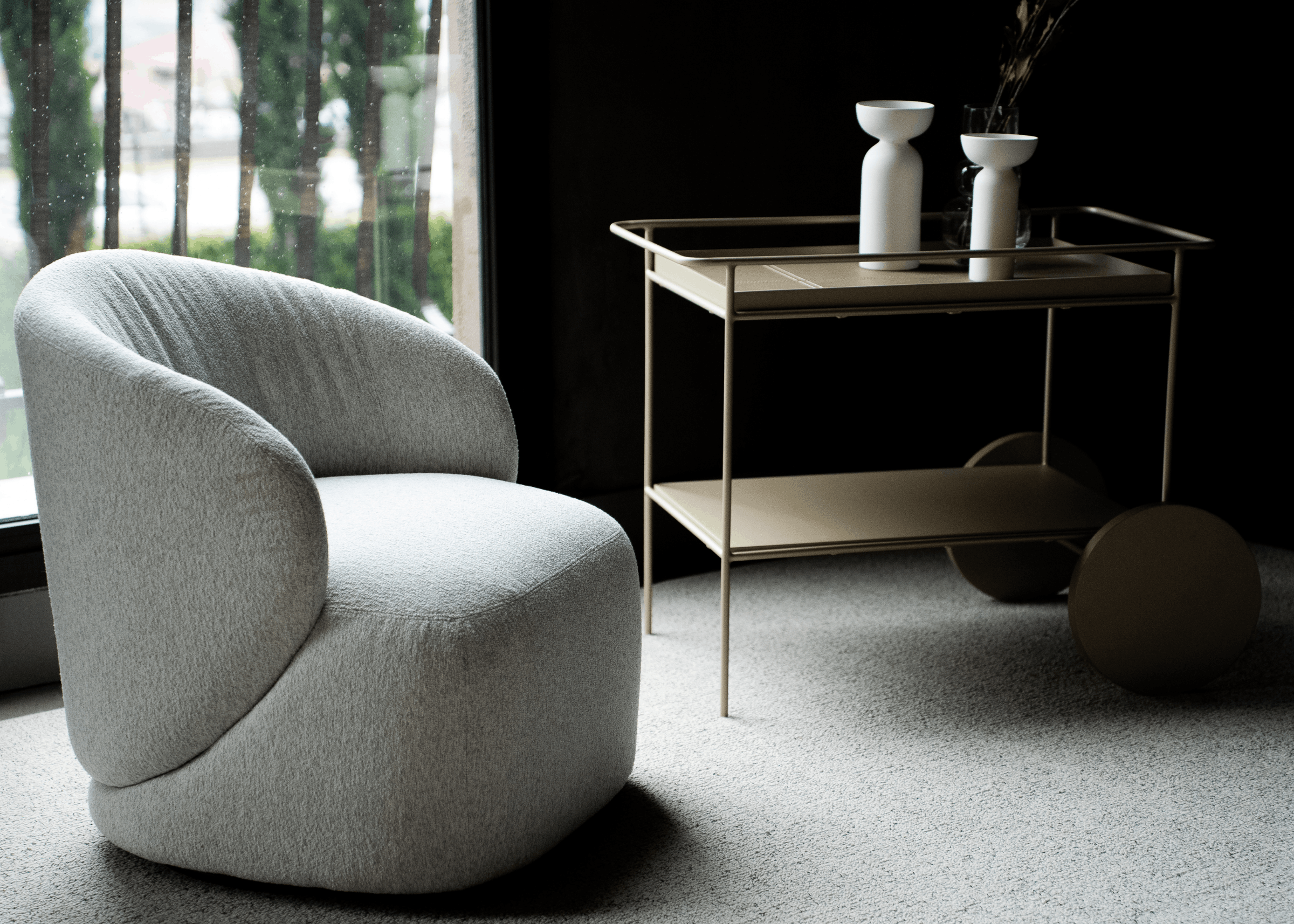 Poltrona Giratória Nilo em sala de estar moderna, com design curvo e tecido claro compondo ambiente sofisticado e aconchegante.