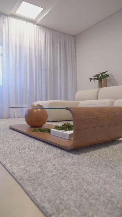 Mesa de centro moderna com design orgânico, tampo em vidro e base em madeira, ideal para sala de estar sofisticada.